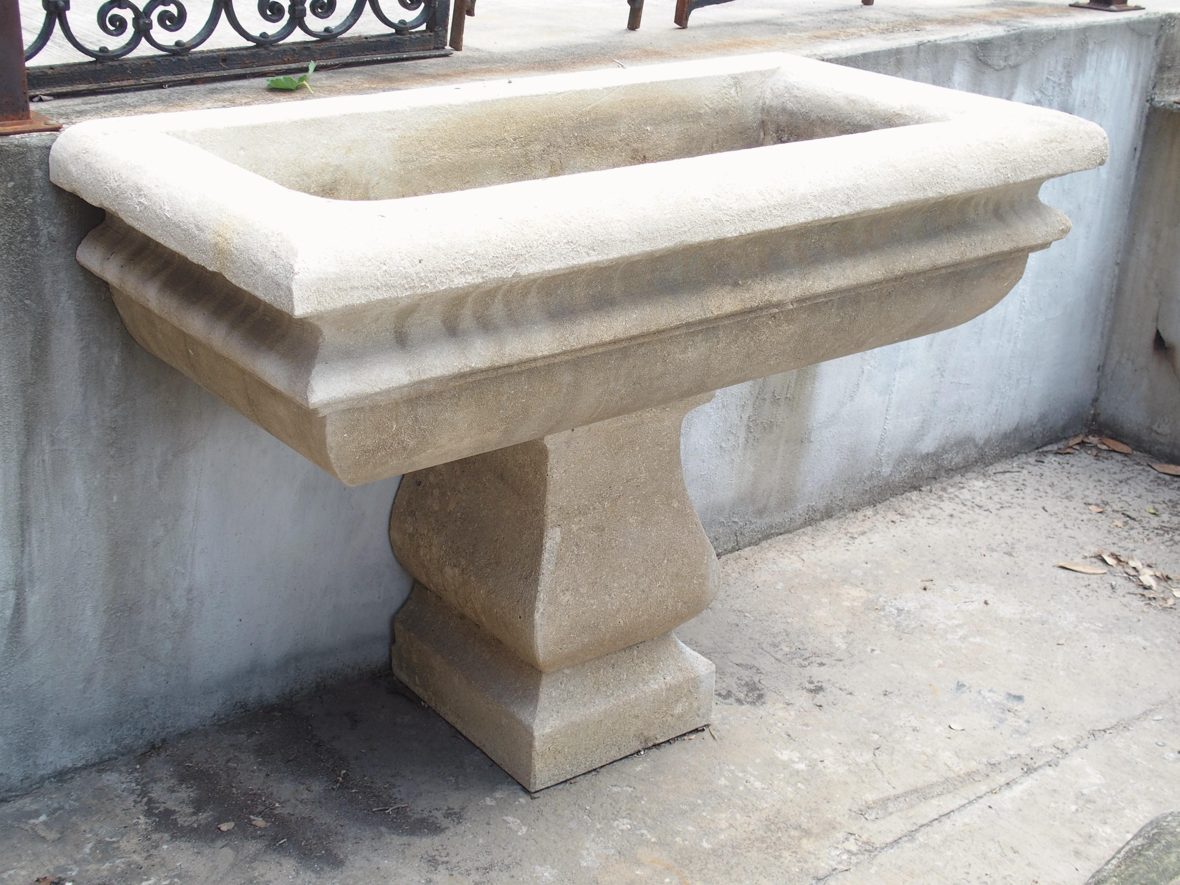 This impressive garden planter was hand-carved from two pieces of solid Italian limestone. The basin features thick quarter round edges with a layer of concave cavetto molding in between. The base is rounded as well, giving the rectangular basin