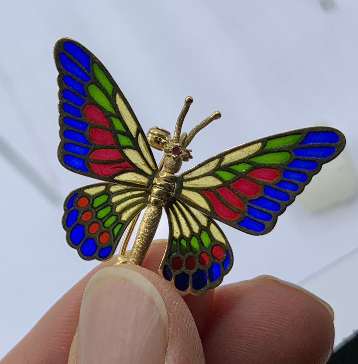 Il s'agit d'une magnifique et rare paire de broches en forme de papillon en or jaune 18 carats avec des yeux en rubis et des ailes en émail Plique-a-jour qui sont articulées de sorte qu'elles peuvent être déplacées dans la position que vous