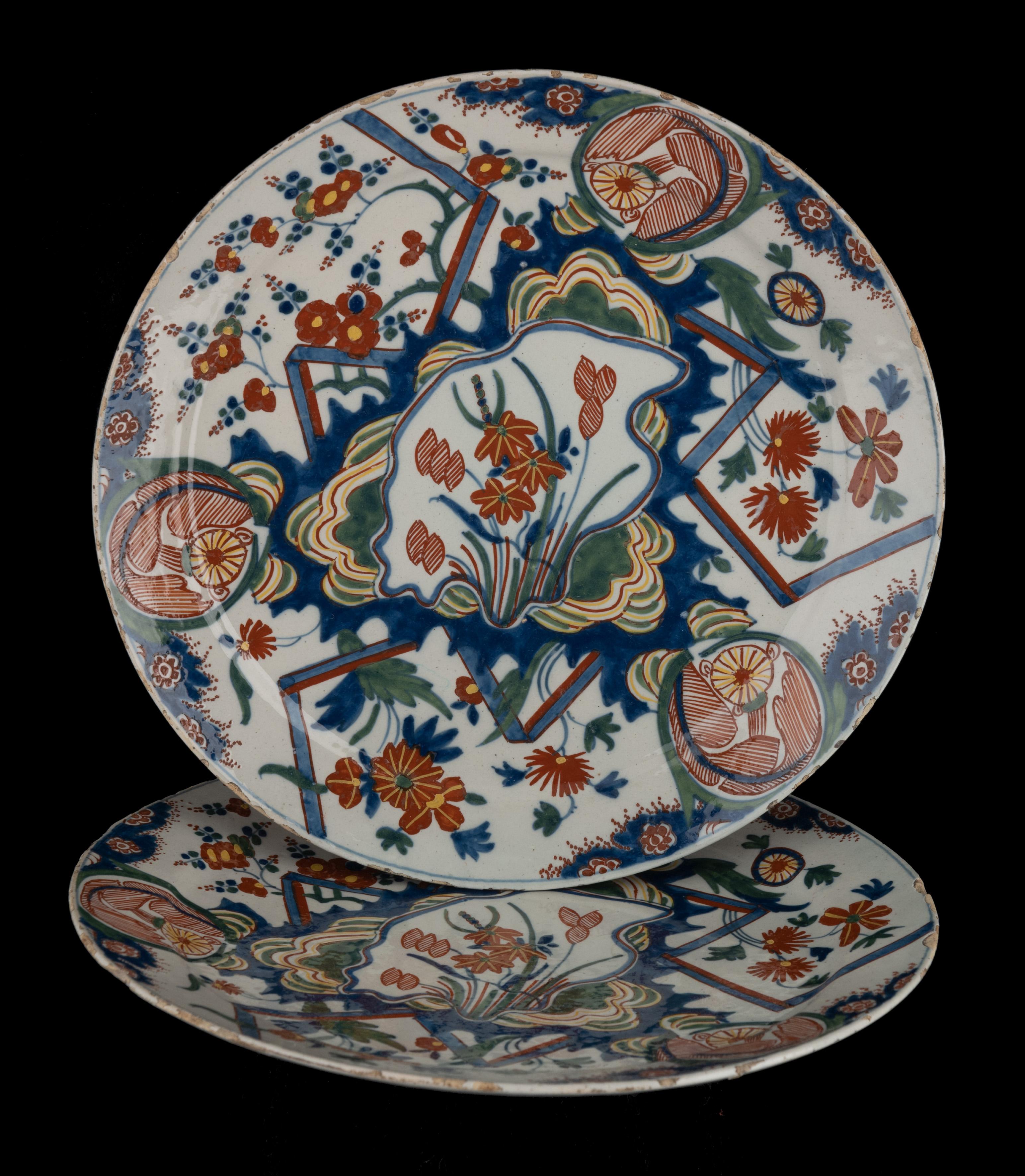 Two polychrome lightning plates Delft, 1700-1730
The Peacock pottery
Mark: D(P)AW 9 

The dish has a small flange and is painted in polychrome with the so-called lightning decor. The center is decorated with an irregular shaped cartouche, filled