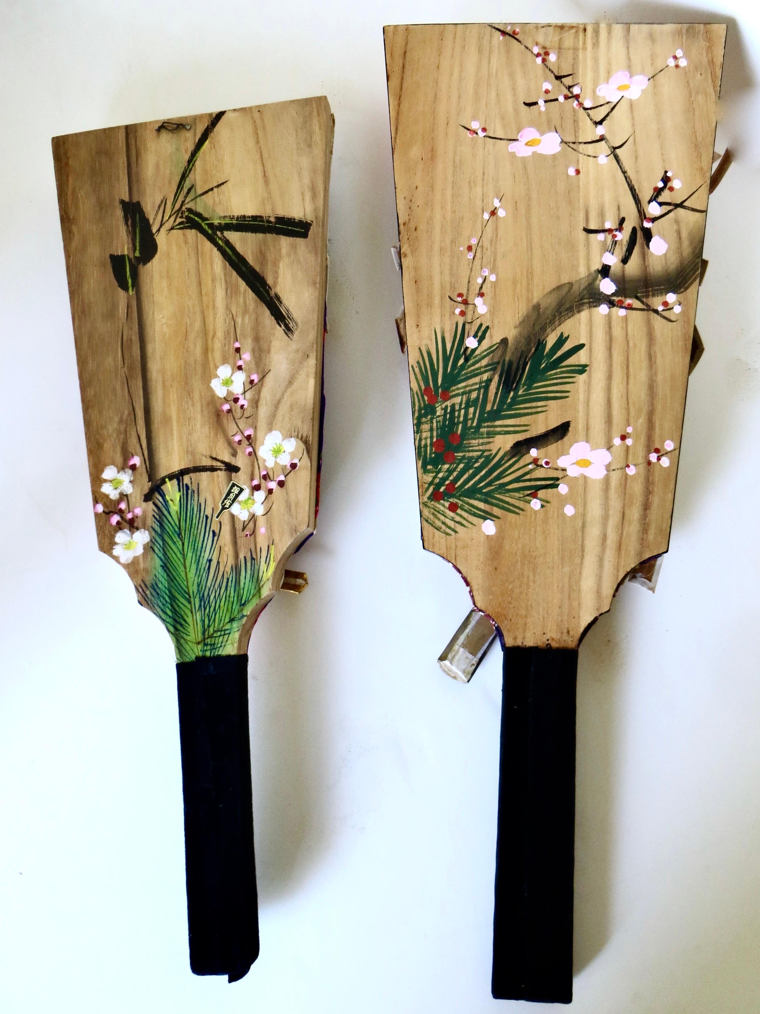 Offered are a pair of post war Japanese Kabuki paddles circa 1960, featuring a male and female Kabuki character actors in full traditional Japanese regalia with weapon mounts in hand. Material is fabric (probably cotton) on wood with hand painted