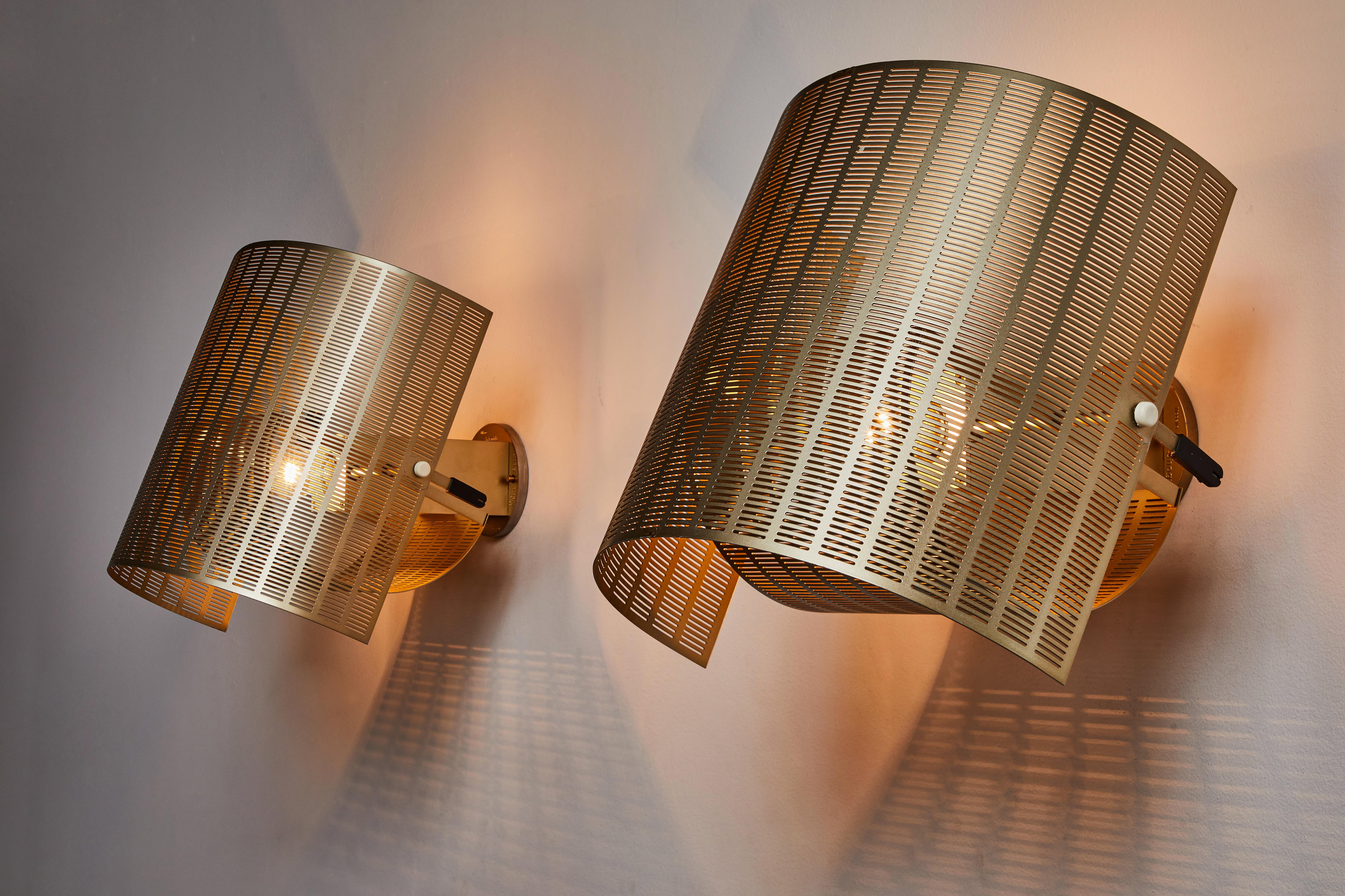 Two rare gold colored shogun sconces by Mario Botta. Designed and manufactured in Italy, 1985. Rewired for U.S. standards. Gold enameled metal. Custom brass backplates. Sconces articulate in an up/down position. We recommend one E27 60w maximum bulb