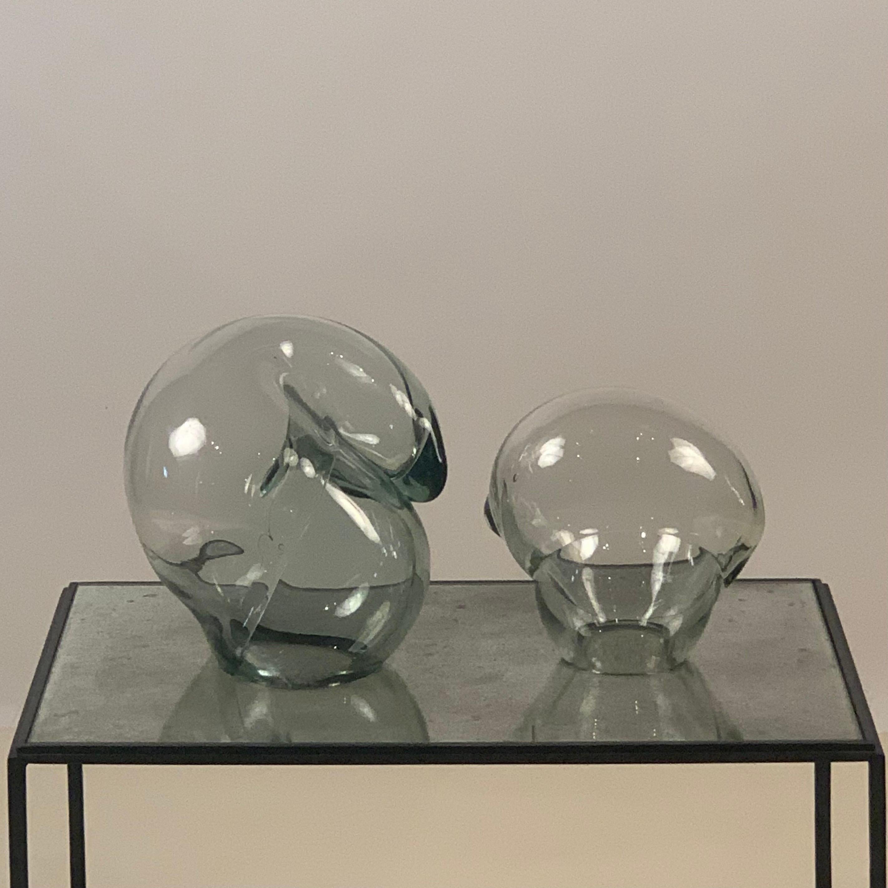 Set of two clear art glass orb sculptures by John Bingham, circa 1980. Signed (engraved) 