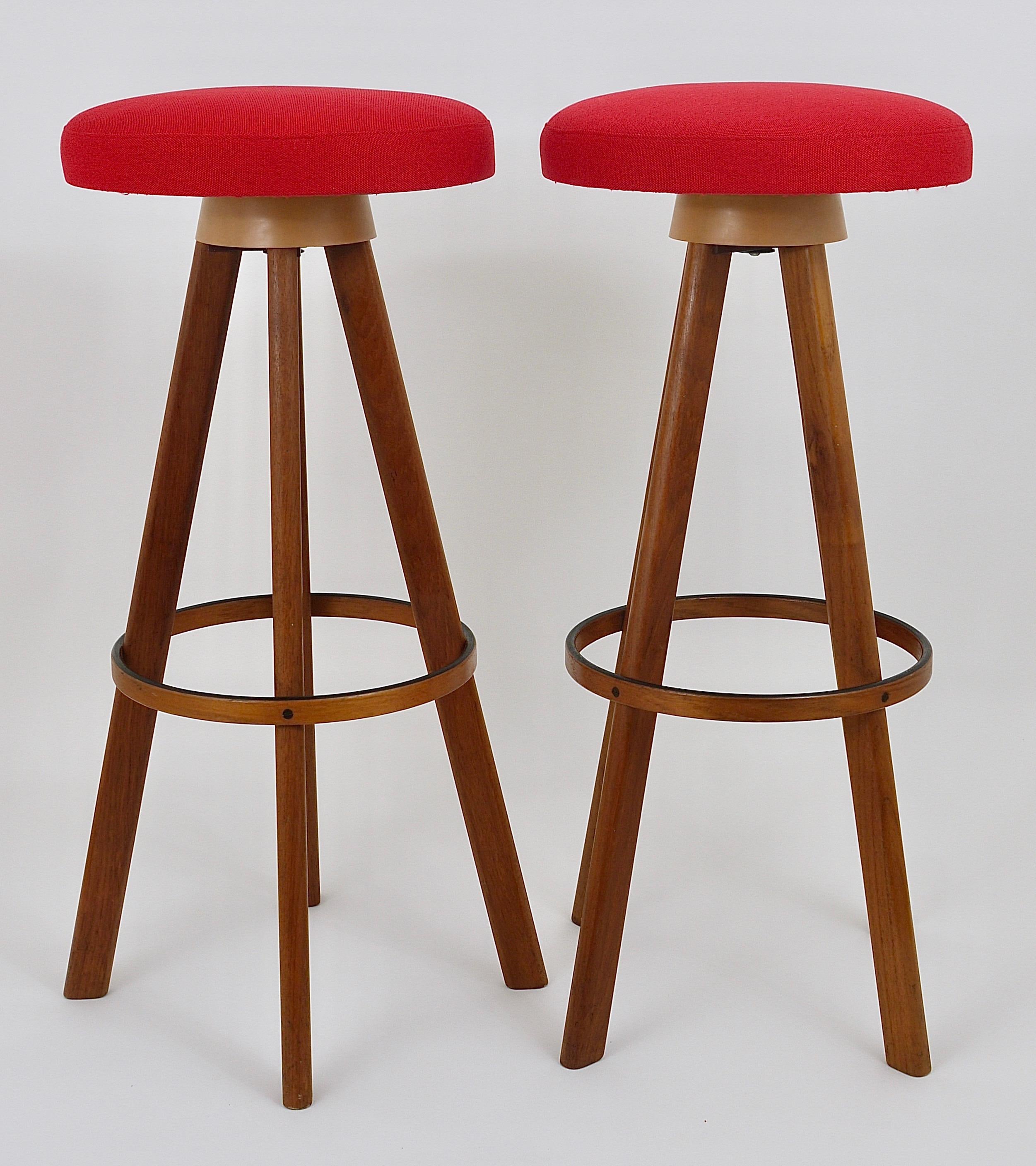 Up to two identical Danish midcentury barstools or counter stools, designed in the 1960s by Hans Olsen executed by Frem Rojle in Denmark. These great looking stools are made of solid teakwood. The swiveling round seats have a red fabric upholstery.