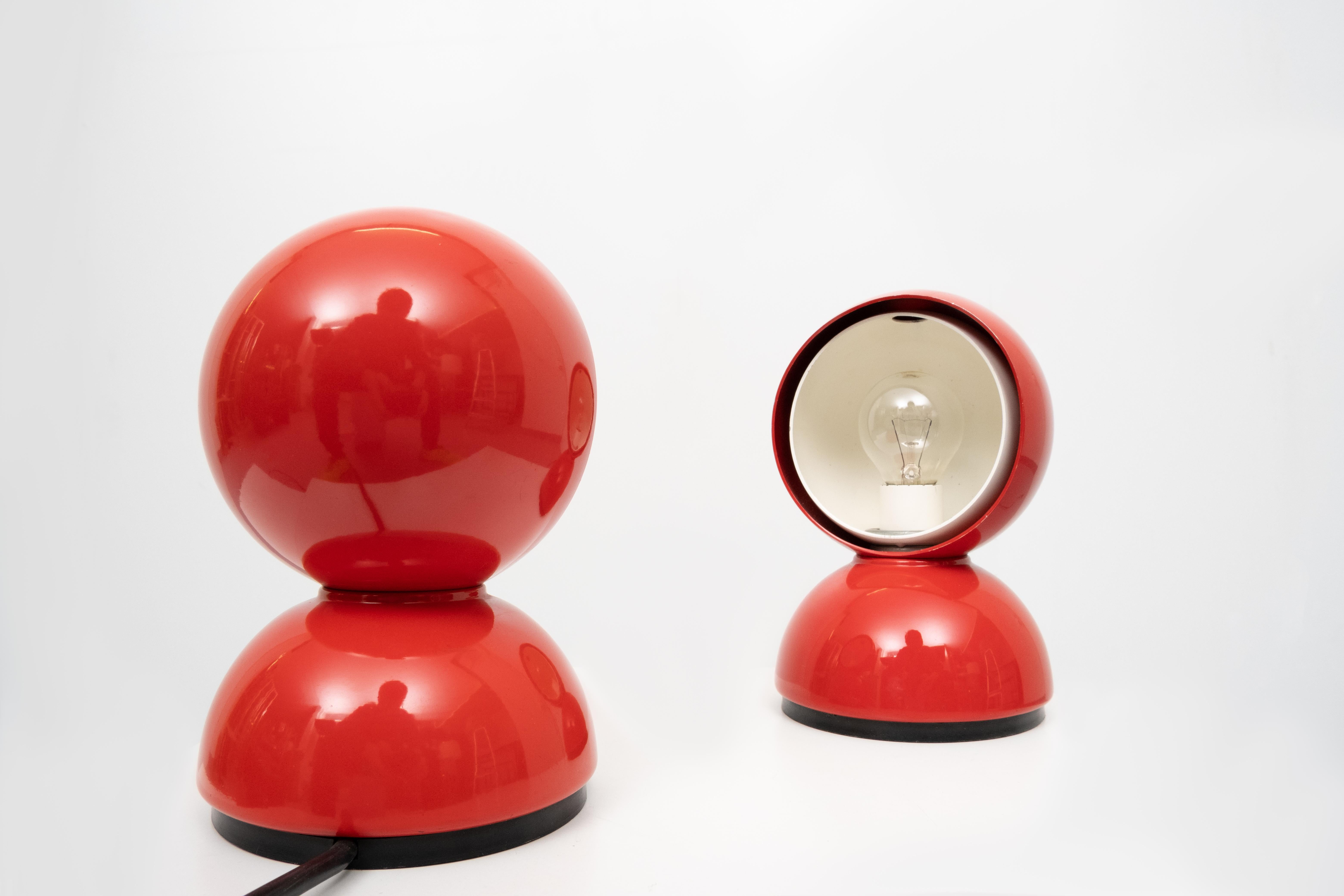 Two red table lamps. Design Vico Magistretti for Artimide Milan 1960s Model Eclisse 
The Artemide Eclisse lamp is composed of 3 half spheres: the base, the fixed outer dome and the mobile inner dome, which is rotated manually and allows you to