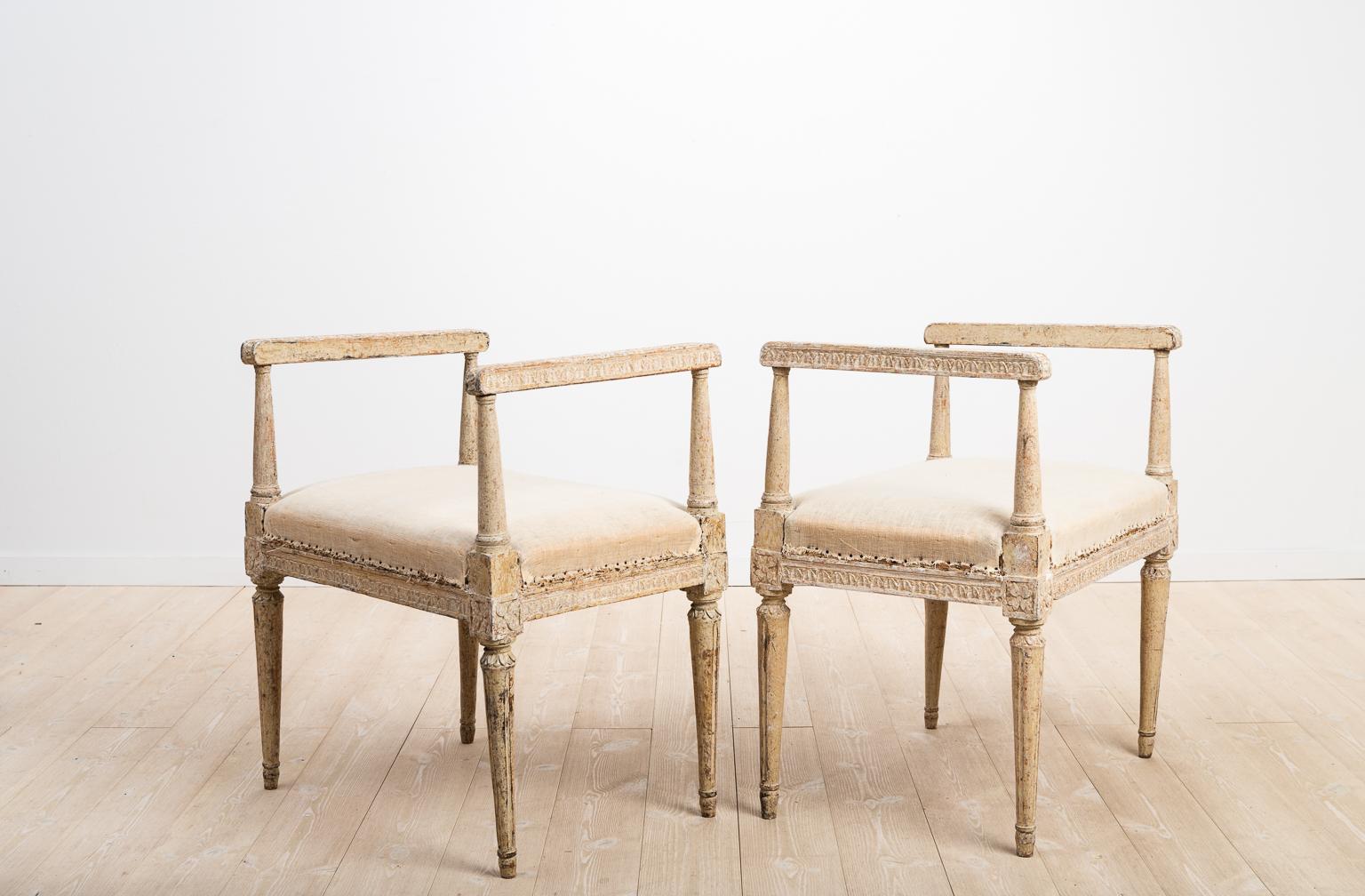 A set of two Gustavian banquettes from Sweden. Richly decorated with Gustavian styled wooden carvings. The surface has been dry scarped to the first layer of paint, which also is from the 1700s. The banquettes are signed at the bottom with the