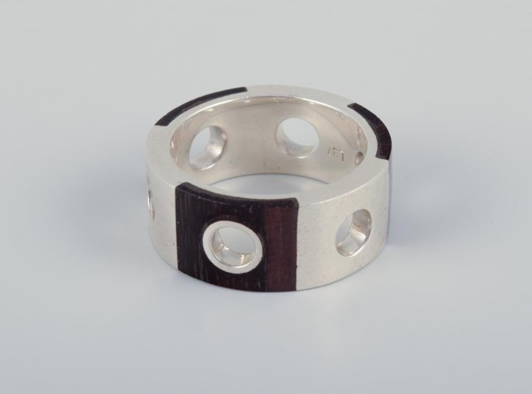 Swedish jewelry artist. Two rings and a pair of earrings in sterling silver and dark wood. Modernist design.
Handcrafted jewelry.
Approximately from the 1980s.
Marked.
Perfect condition.
Rings: 20 mm (US size 9) / 16 mm. (US size 5)
Earrings: Length