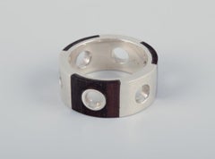 Two rings and a pair of earrings in sterling silver and dark wood. 1980s