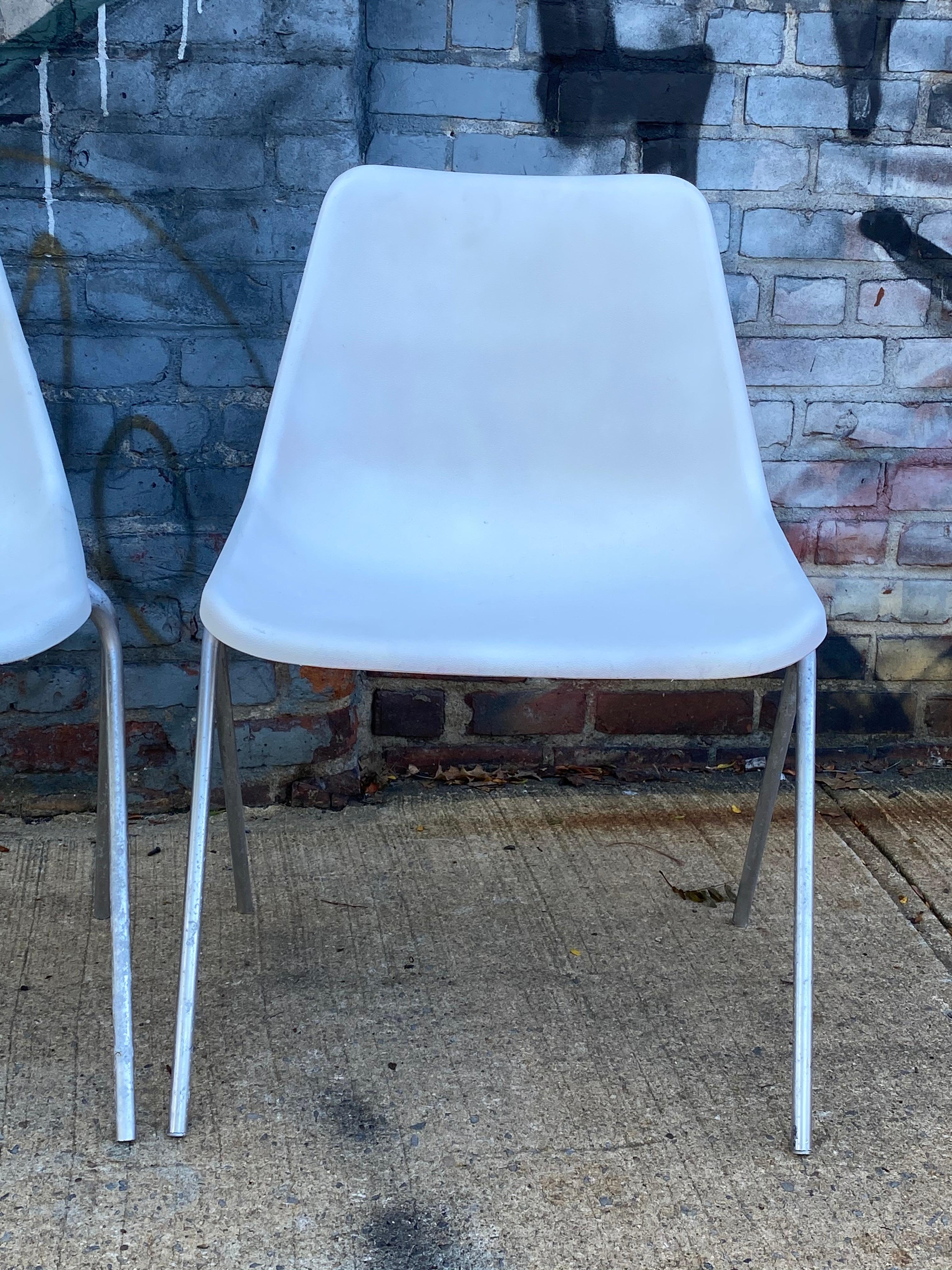 Ein Paar stapelbarer Kunststoffschalenstühle im Eames-Stil. Entworfen von Robin Day und hergestellt von der John Stuart Furniture Company. Stühle in gutem Zustand. Leicht stapelbar zur Reinigung oder Lagerung. Bequem und für den normalen Gebrauch