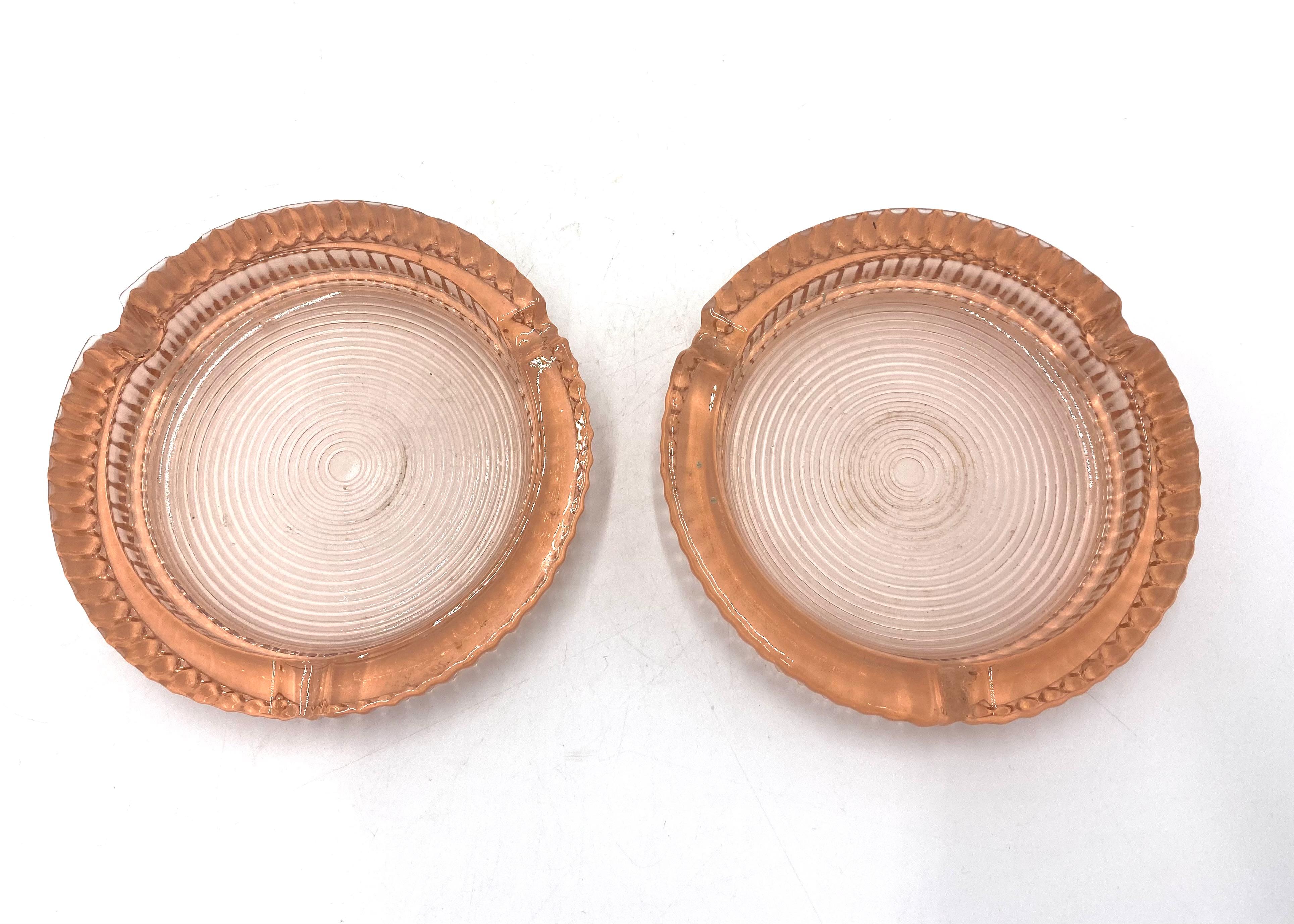 Two salmon / rose colored glass ashtrays

Very good condition

Made in Poland in the 1930s

height 2 cm, diameter 12.5 cm.
