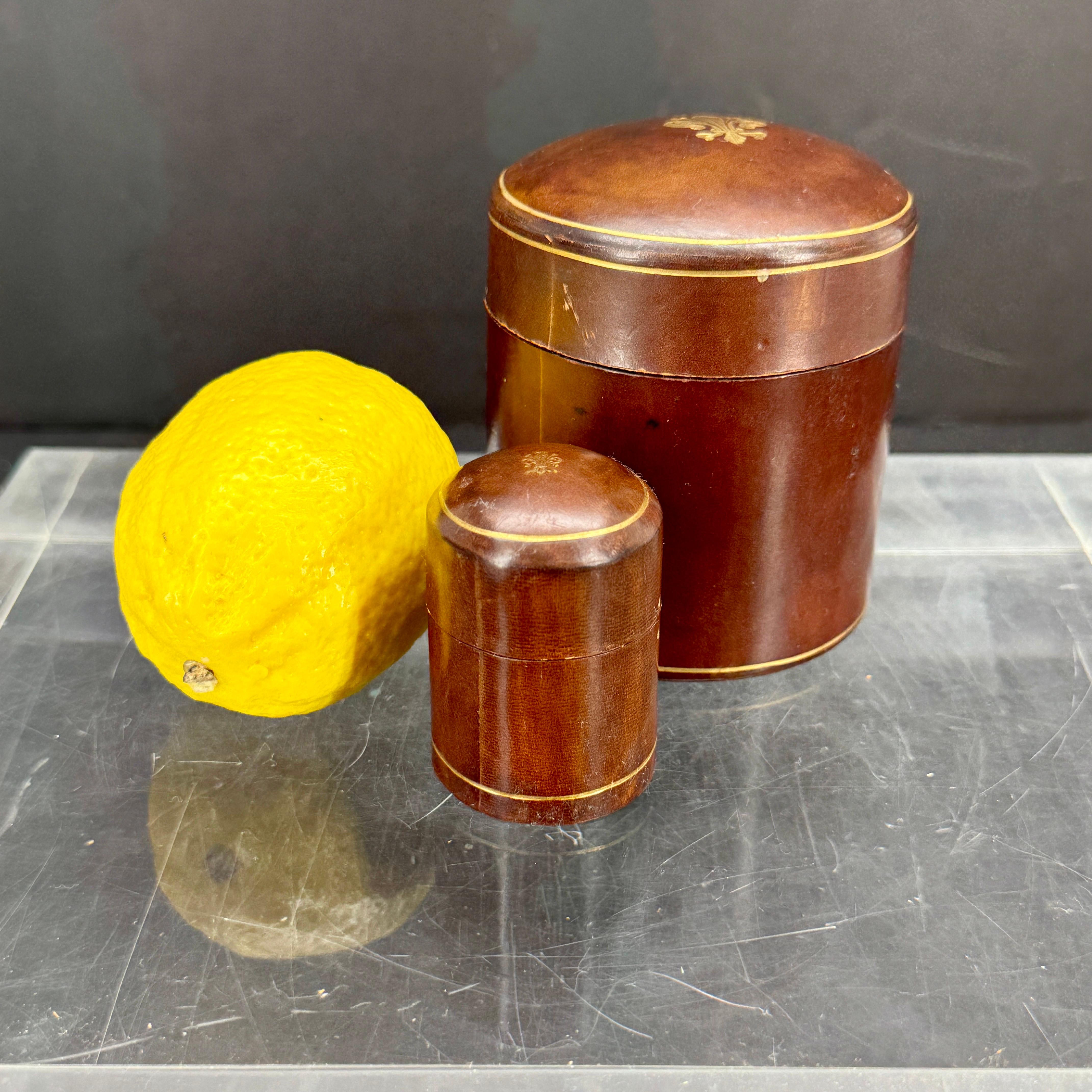 Charming Mid-Century set of two Italian hand crafted boxes in leather and gold embossed with fleur-de-lis decoration. The boxes can be used to store your favorite pieces of jewelry as well a stand alone piece on a coffee table as decoration. Stamped