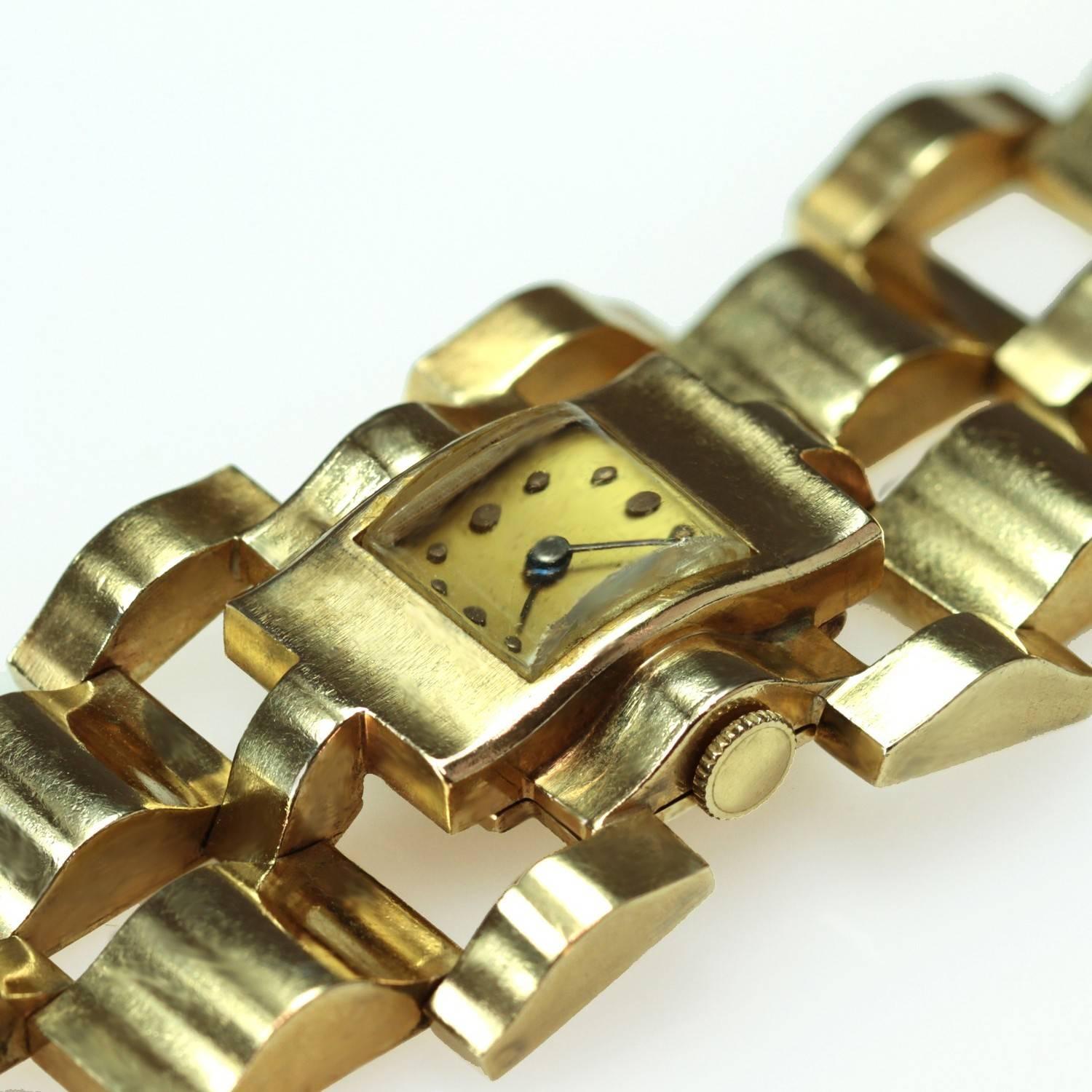 A stylish circa 1940s retro watch made in 14k yellow gold. This women's timepiece features mechanical hand movement, a black dial, and a hidden safety clasp. Measurements: 1.18