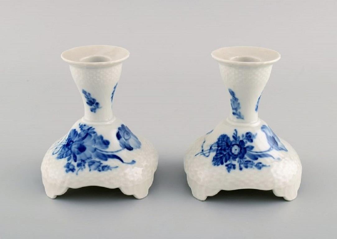 Deux chandeliers courbés en forme de fleur bleue de Royal Copenhagen. Numéro de modèle 10/1711. 
Daté de 1965.
Mesures : 10.5 x 10,5 cm.
En parfait état.
Estampillé.
1ère qualité d'usine.