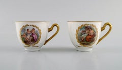 Two Royal Copenhagen coffee cups with saucers decorated with flowers.