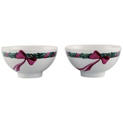 Due ciotole Jingle Bells di Royal Copenhagen, decorate con abete rosso e nastro.
