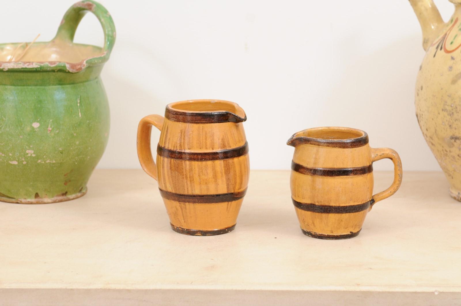 Two rustic French pottery pitchers from the 19th century, with yellow glaze, brown accents and back handles. They are priced and sold individually, $250 each. Created in France during the 19th century, each of these pitchers features a yellow glazed