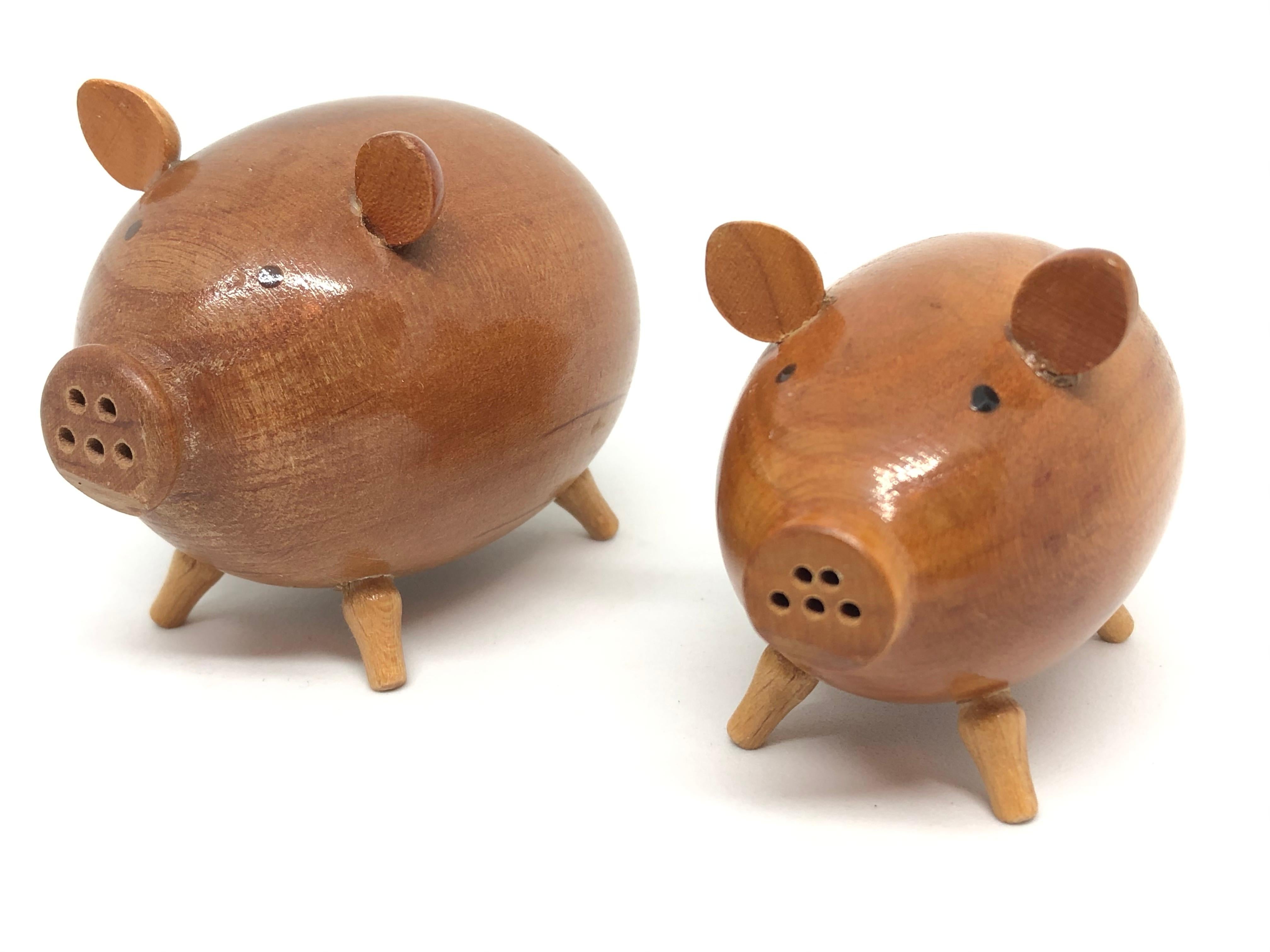 Classic early 1960s Danish design wood salt and pepper shaker set of two in the form of a pig. Nice addition to your table or just for your collection of Design items. Made of teak wood. Found at an estate sale in Vienna, Austria. The tall one is