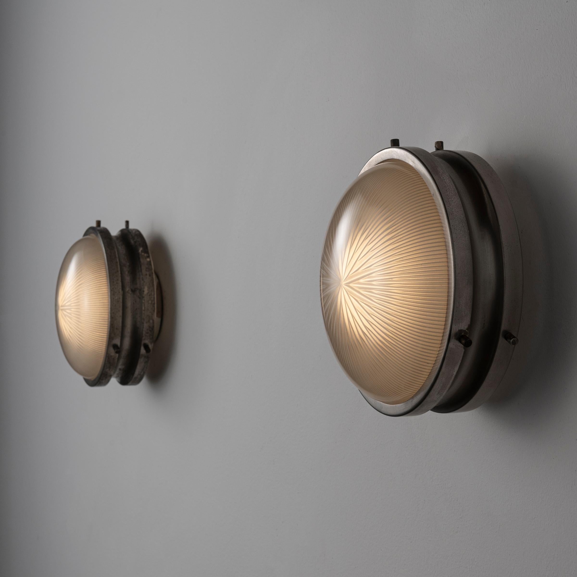 Sconces by Sergio Mazza. Designed and manufactured in Italy, circa 1960s. Patinated nickel plated brass, holophane glass. Custom backplates. Rewired for U.S. standards. We recommend three e27 40w maximum bulbs per sconce. Bulbs provided as a one