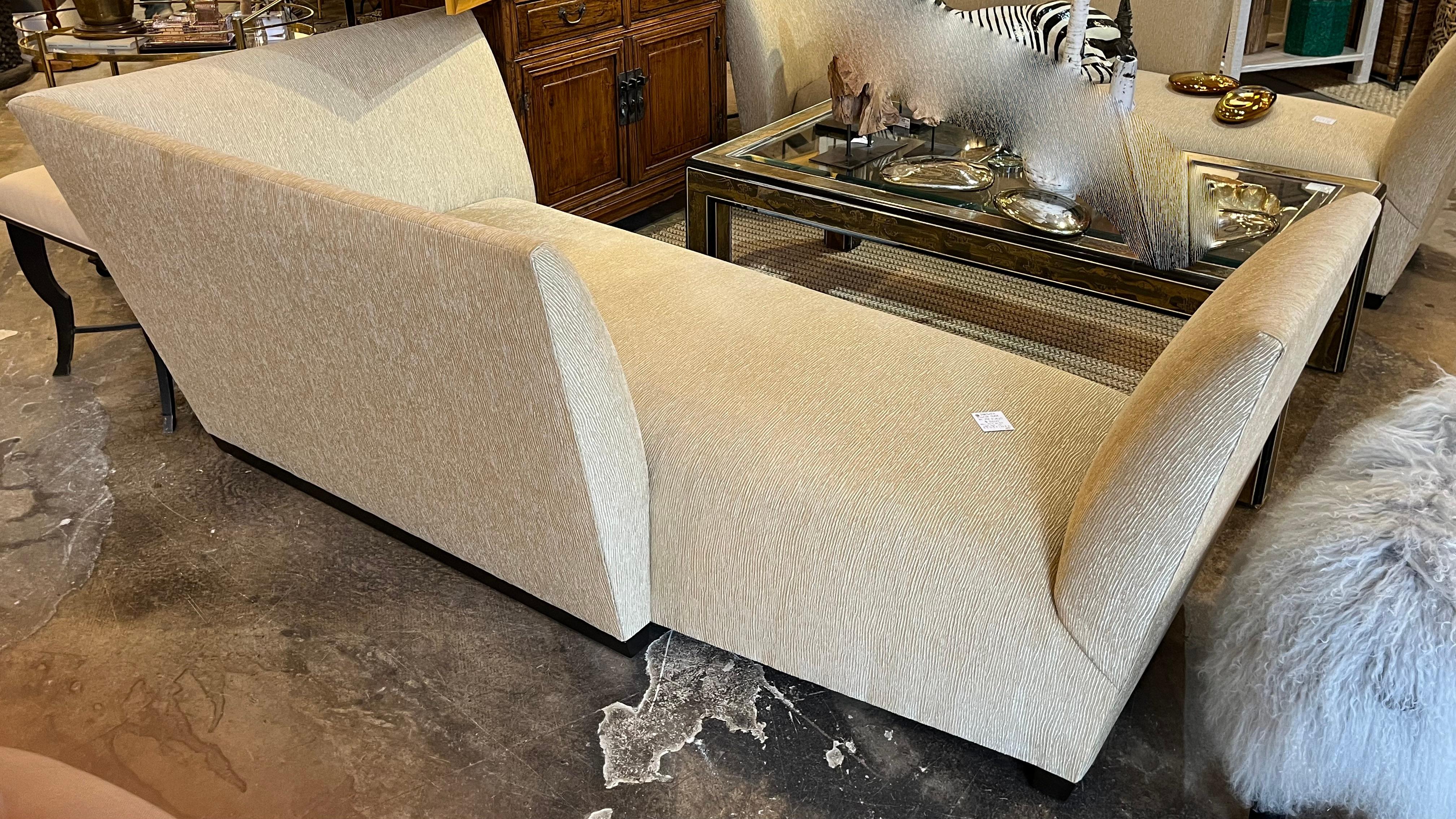 A pair of Donghia sculptural sofas designed by Joe D'urso having soft ecru chenille upholstery.