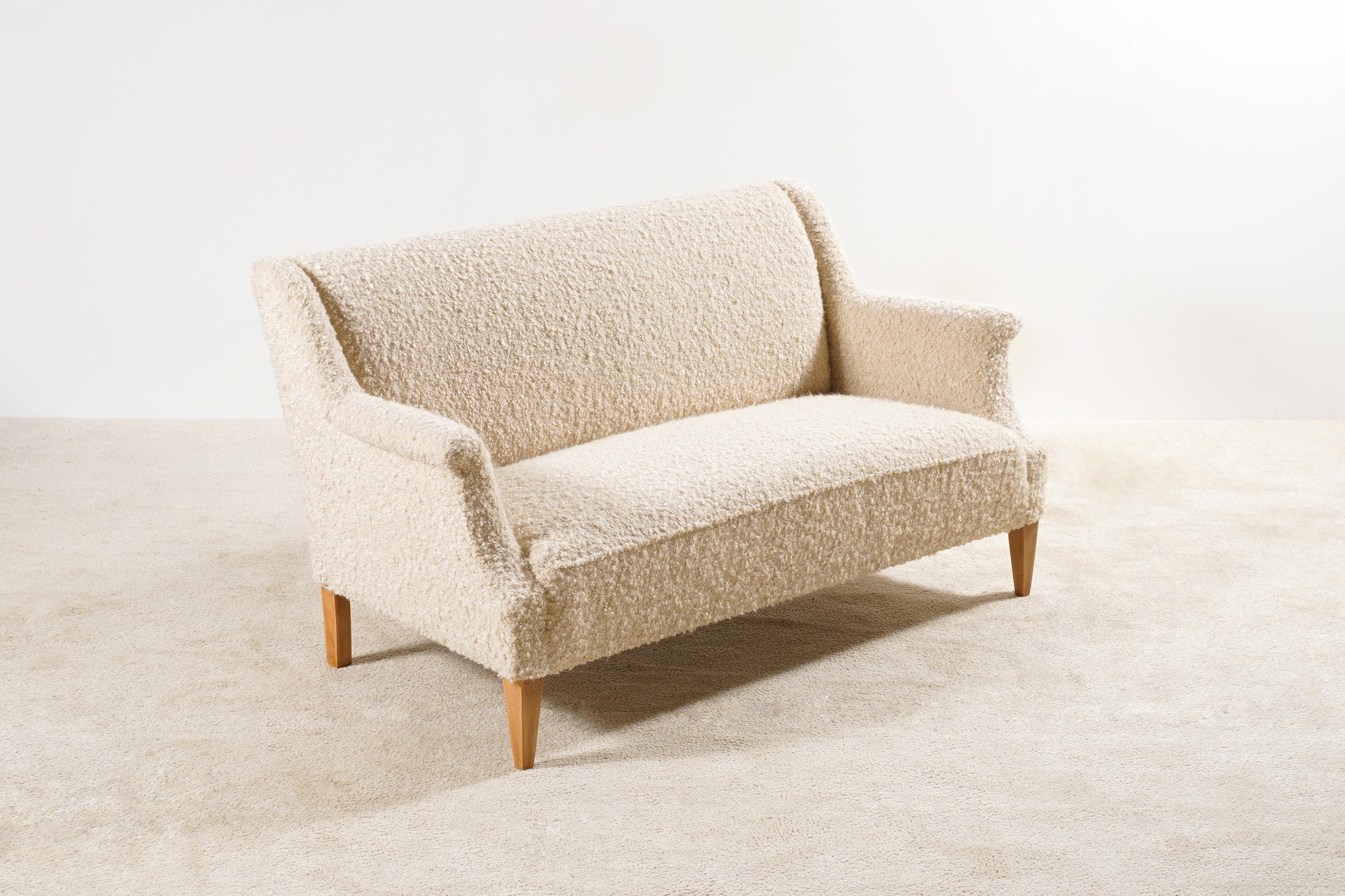 This two-seat bouclé sofa is an original piece from the 1940s, manufactured in Denmark.
Beechwood natural color waxed feet.

This sofa has been fully restored and newly upholstered in the traditional way by the best French craftsmen, we used a