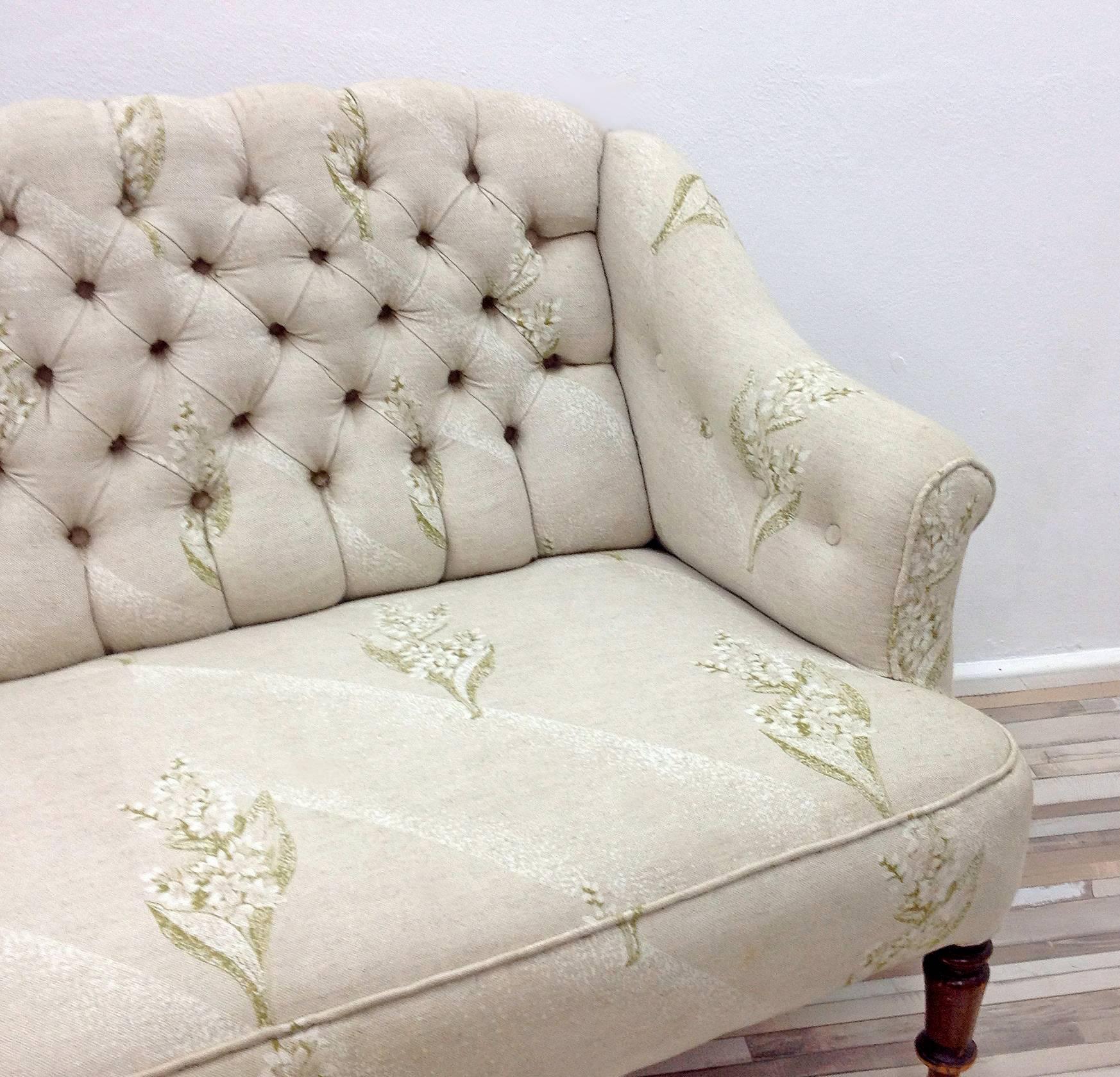 This small sofa originates from the 1940s. It features a classic quilted backrest and new linen upholstery. The front legs are finished with brass rings. Ringhs are a high-quality new Italian production stylized for the 40 years. The sofa has been