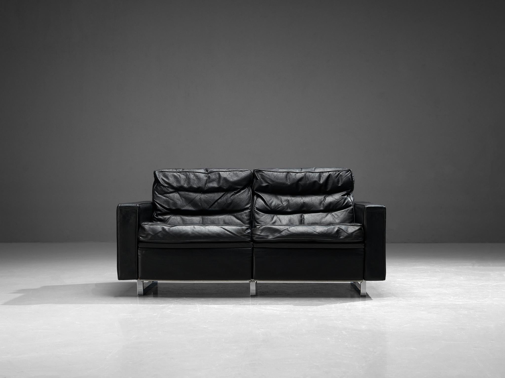 Canapé, cuir, Europe, années 1960.

Ce canapé deux places est simpliste, mais son design est élégant. Grâce à la couleur noire générale du similicuir, le canapé rayonne de douceur et souligne le design épuré. Il met donc en valeur les lignes droites