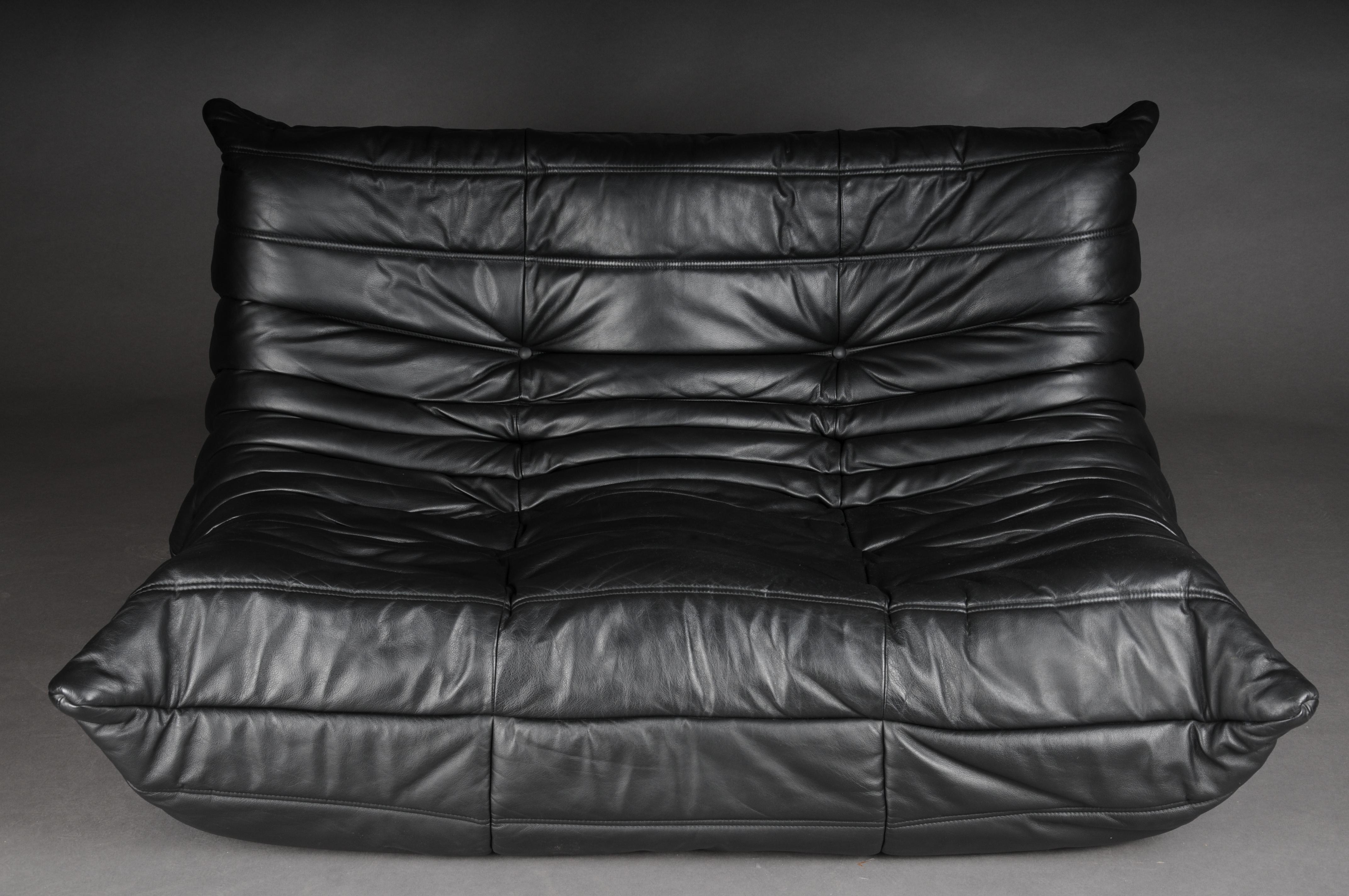 Two seater Togo sofa, black leather by Michel Ducaroy, Ligne Roset, France,

Originally designed in the 1970s, the iconic Togo sofa is now a design classic. This stunning jet black leather sofa still has the original tags and fabric lining