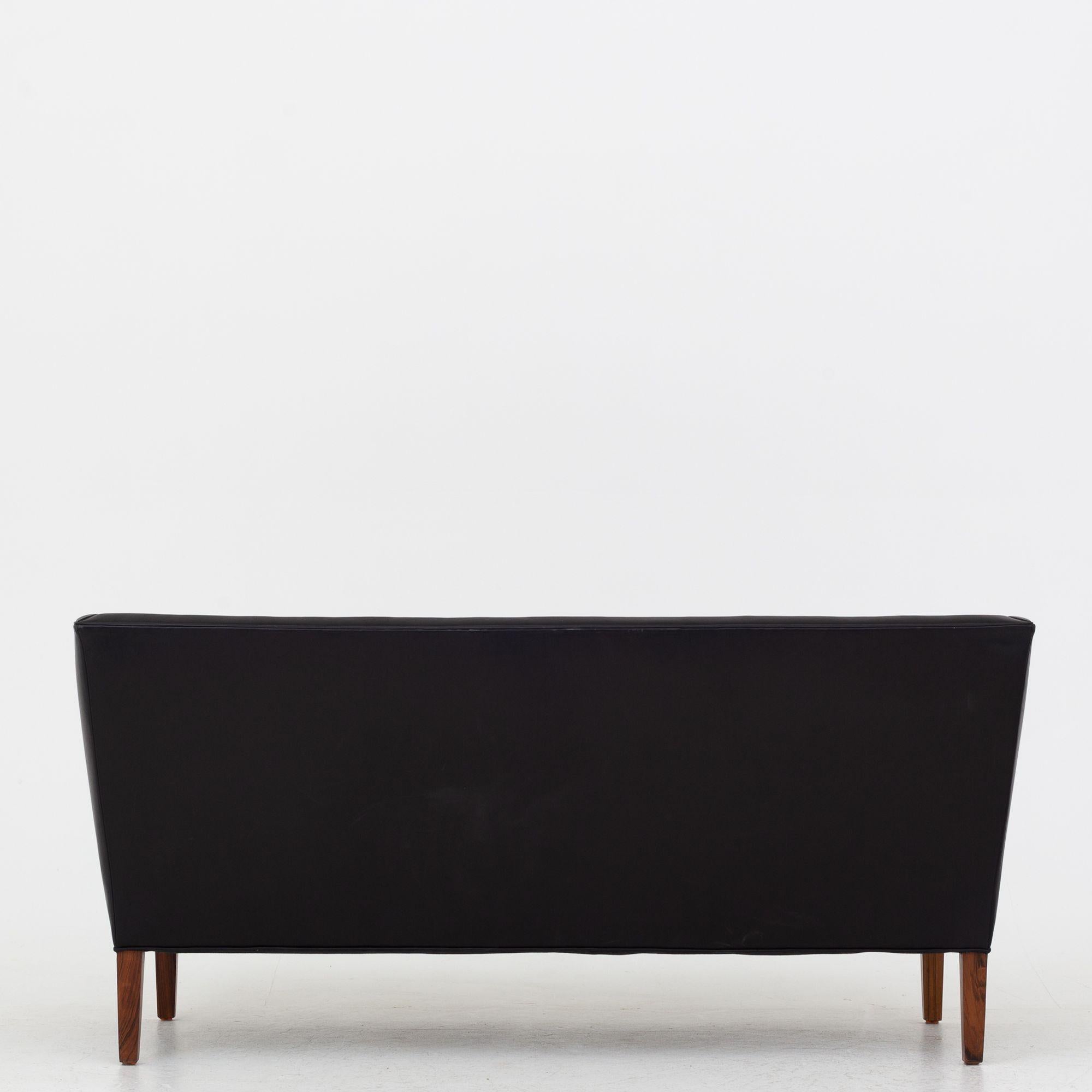 2-Sitzer-Sofa aus schwarzem Leder und Beinen aus Palisanderholz. Grete Jalk / Johannes Hansen.