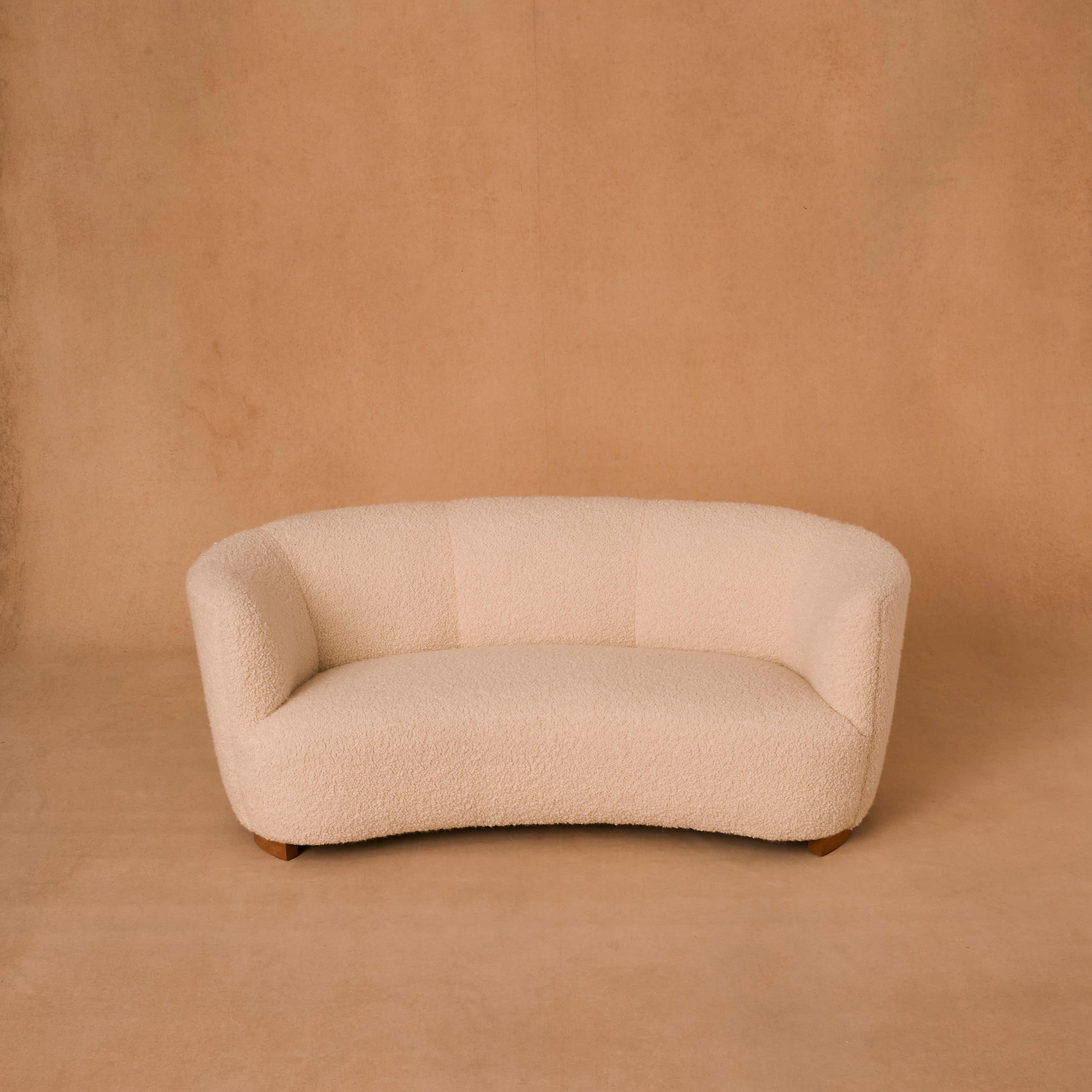 Two seater Danish banana sofa reupholstered in Ivory coloured soft Alpaca Wool Boucle.