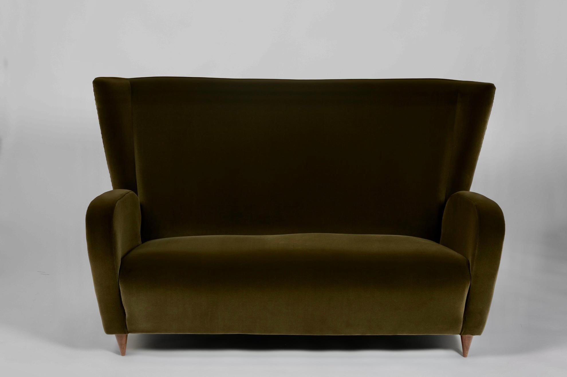 A beautifully restored two-seater wingback sofa designed by Paolo Buffa, Italy, c.1950. Originally designed for the Hotel Bristol in Merano, this 1950s settee has been completely restored and re-upholstered in a luxurious green cotton velvet named