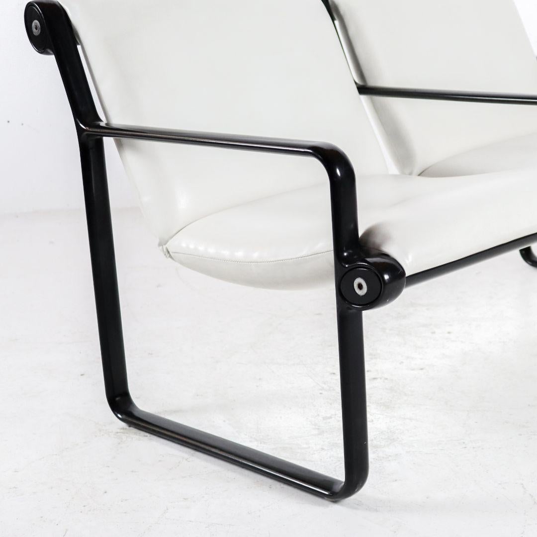 Two seater sofa by Bruce Hannah & Andrew Morrison for Knoll International. The solid 1970s sofa has a black powder-coated steel frame with a white faux leather upholstery. The two seats hang (firmly) between the frame, to create a 'sling'