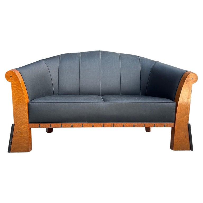 Small, faceted sofa/settee designed by Michael Graves composed of a stained Birdseye Maple frame with ebony inlaid triangles and applied ebonized cylindrical decorations at the feet. 
Scarcely seen piece by the noted architect remaining highly