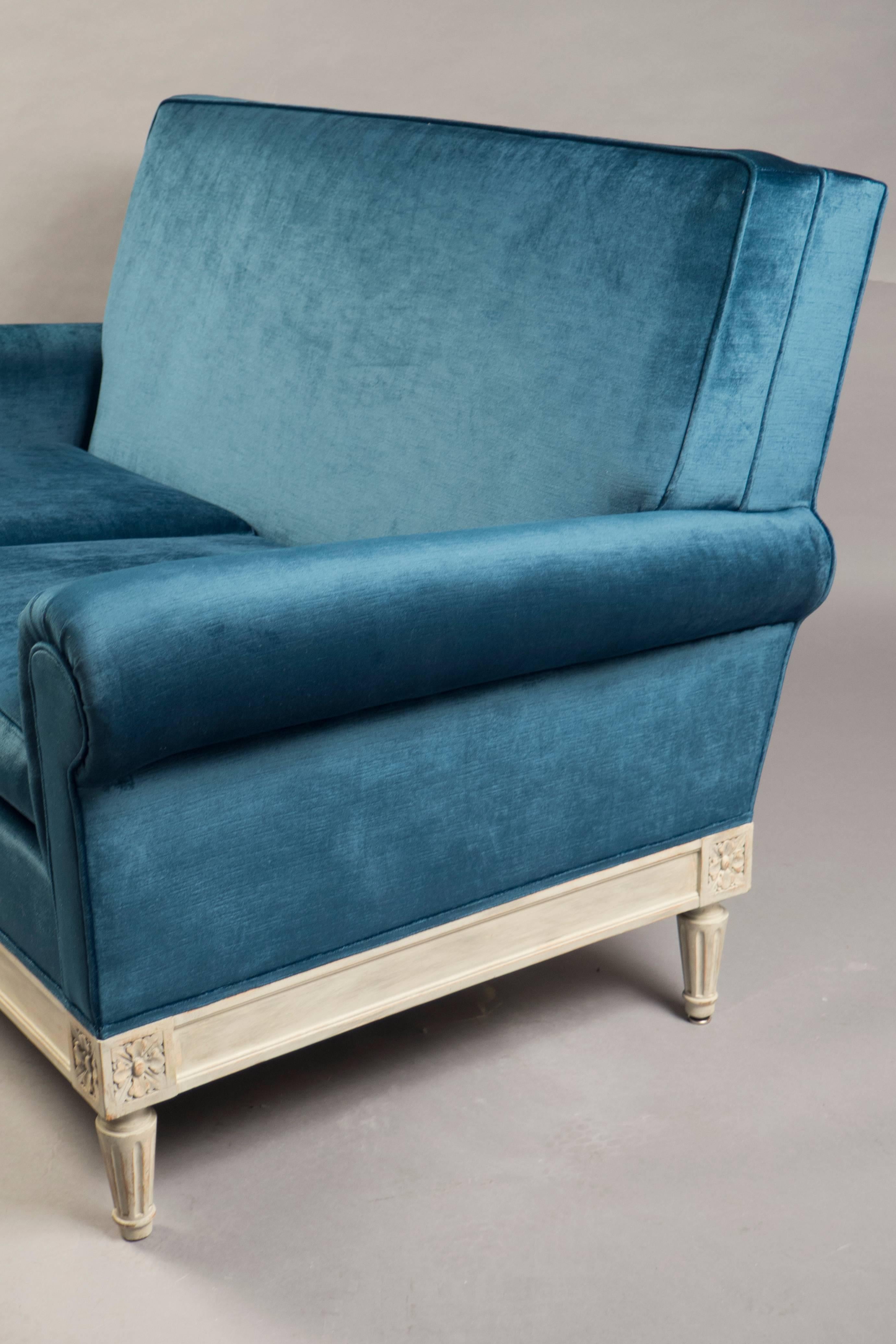 Two-seat sofa with a white-washed wooden base with classical rosette carvings and tapered legs, supporting an over-upholstered seat, back and sides, covered in rose Cumming’s antique blue velvet.

Measures: Height back 33.5”, width 54”, depth