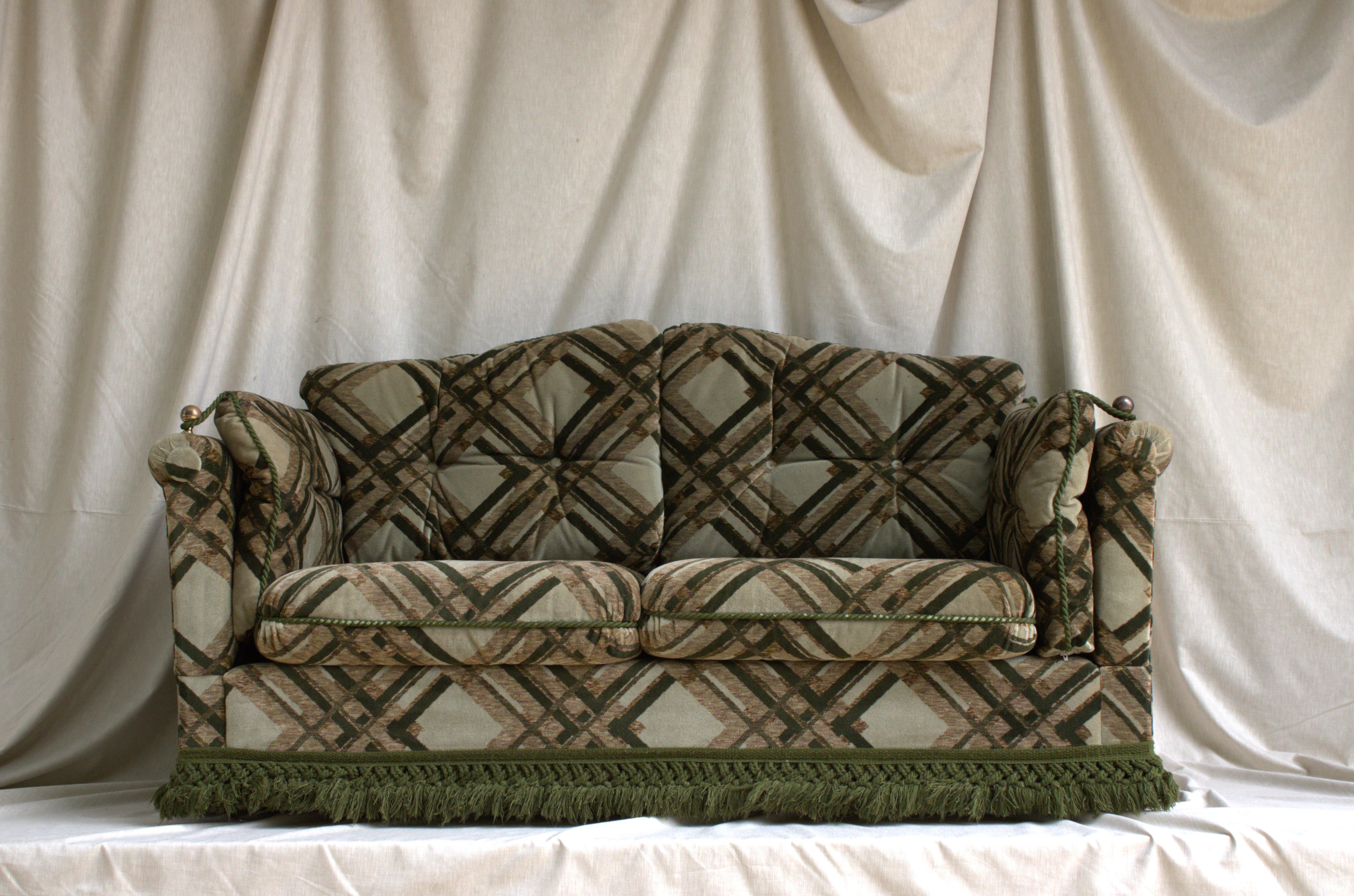 A canapé by Maison Jansen, is a classic piece of furniture that was produced in France during the 1960's. Features a combination of green and beige geometric upholstery, of a velvet fabric. The sides of the sofa can be tilted. It's structure is of