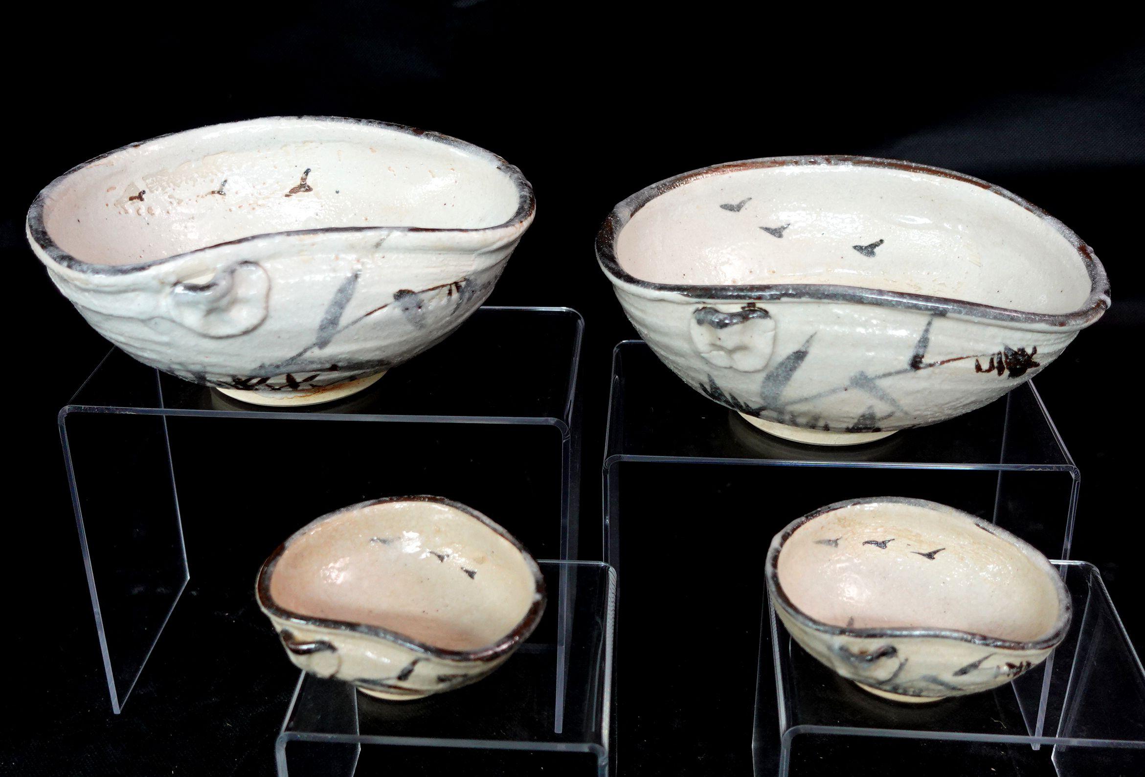 A set of Japanese ceramic bowls and sauce dish set with dark rims and soft organic form. H: 3 in (7.6cm) W: 6 in (15.24 cm) L: 7 in (17.78 cm)H: 3.5 in (8.89 cm) W: 3 in (7.6 cm) L: 2 in (5.1 cm)