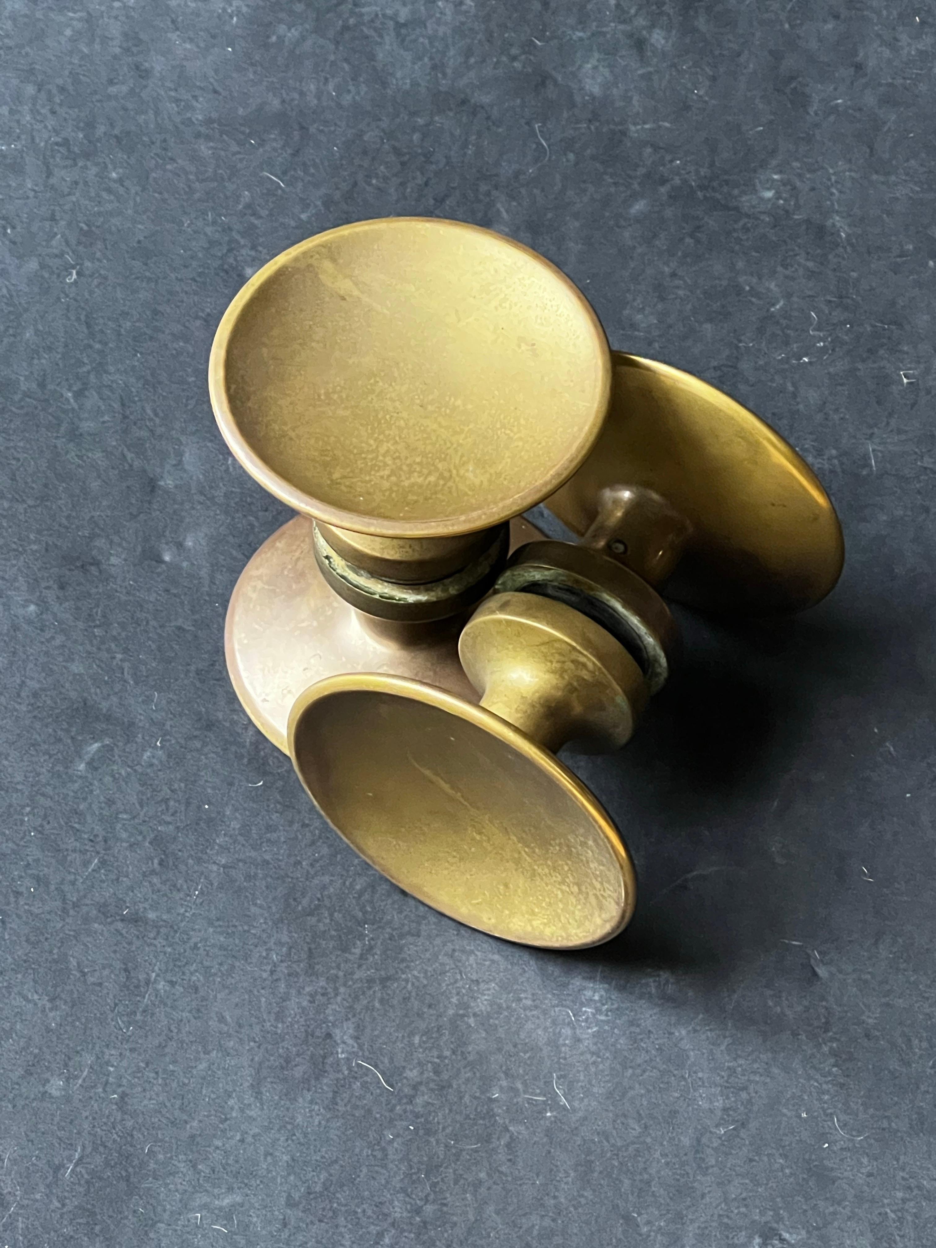 Due maniglie circolari di medie dimensioni in bronzo, metà del XX secolo, Francia.

Due semplici maniglie, ciascuna composta da due piastre rotonde leggermente sagomate, sostenute da un bullone di collegamento, come mostrato nell'immagine 1. I