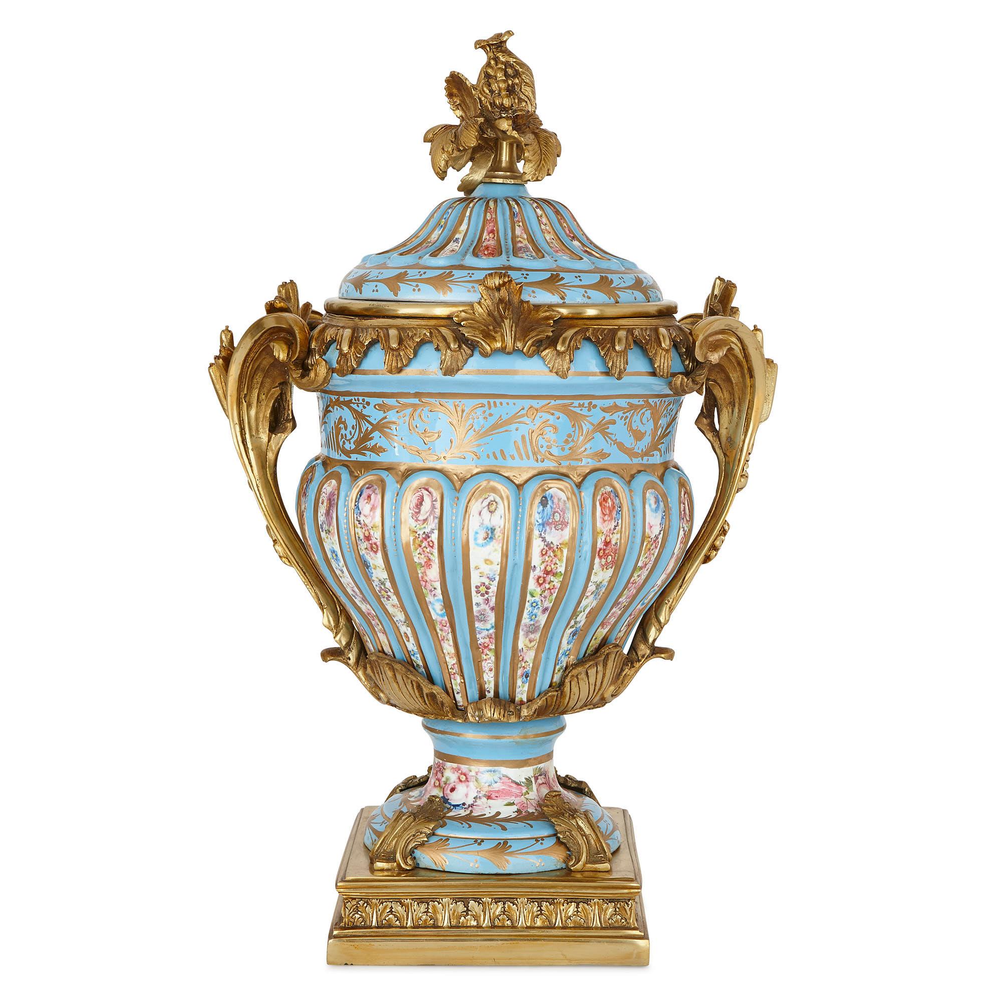 This exquisite pair of sky blue porcelain vases feature colourful paintings of flowers and parcel gilt motifs, enhanced with elaborate gilt bronze mounts. The pair take the form of classical kraters, with their wide upper bodies, necks and mouths.