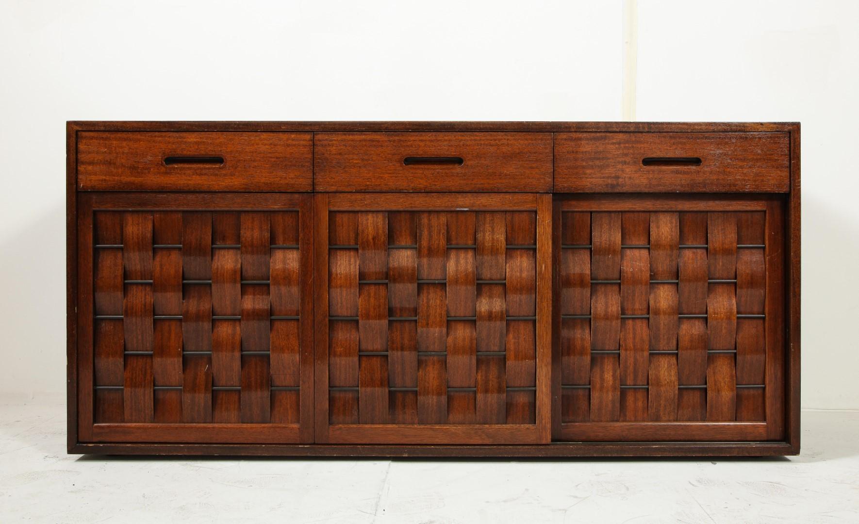 Two signed Edward Wormley for Dunbar ebonized walnut woven front credenzas with brass fittings. One piece is a darker walnut than the other so they are not exactly matching in coloration. The two cabinets are the same dimensions; each have three