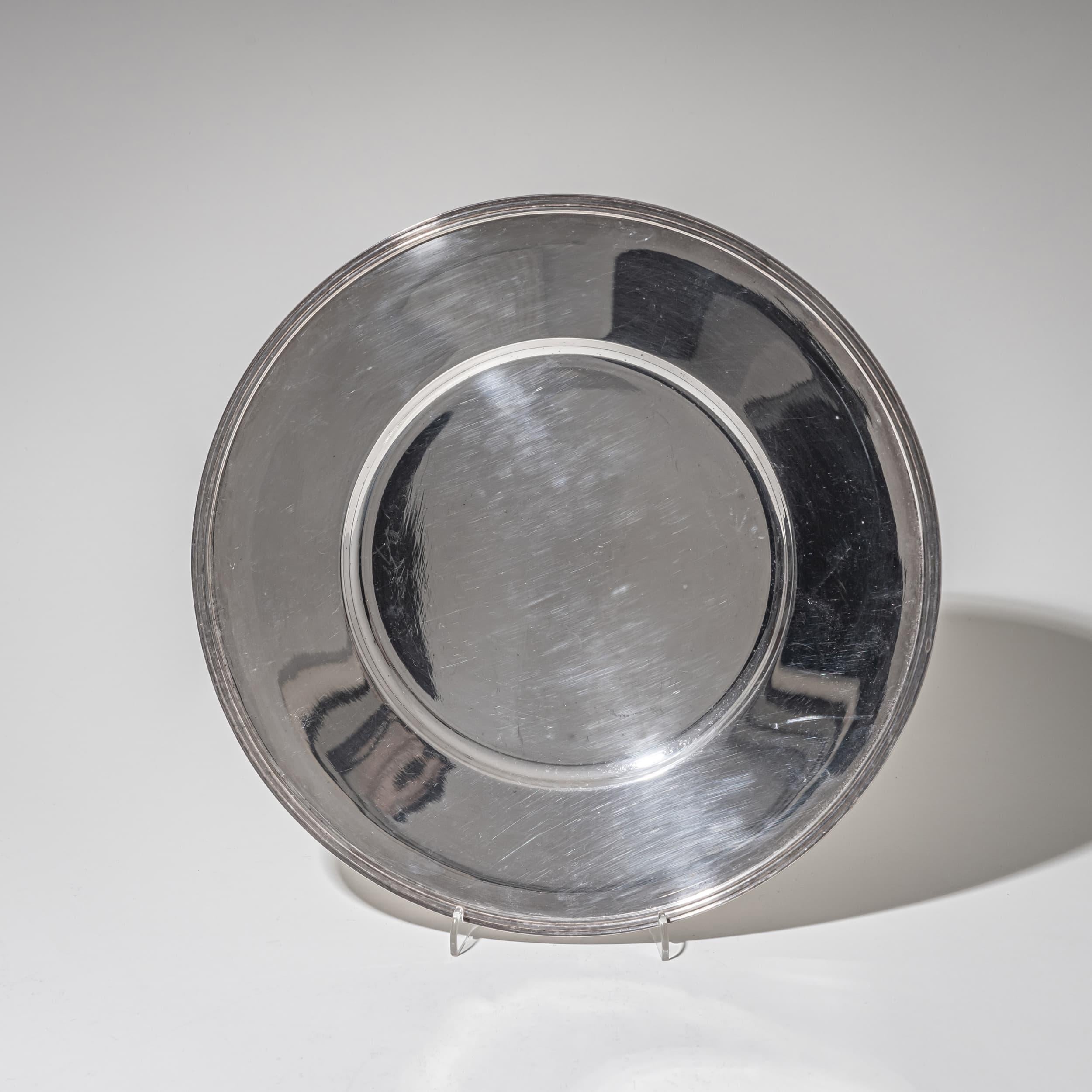 Coppia di piatti da portata minimalisti in argento con pozzetto liscio e bordo liscio. Il bordo sottilmente profilato aggiunge un tocco di sobria eleganza. Timbrato: Wilkens. Peso totale: 1.009 g