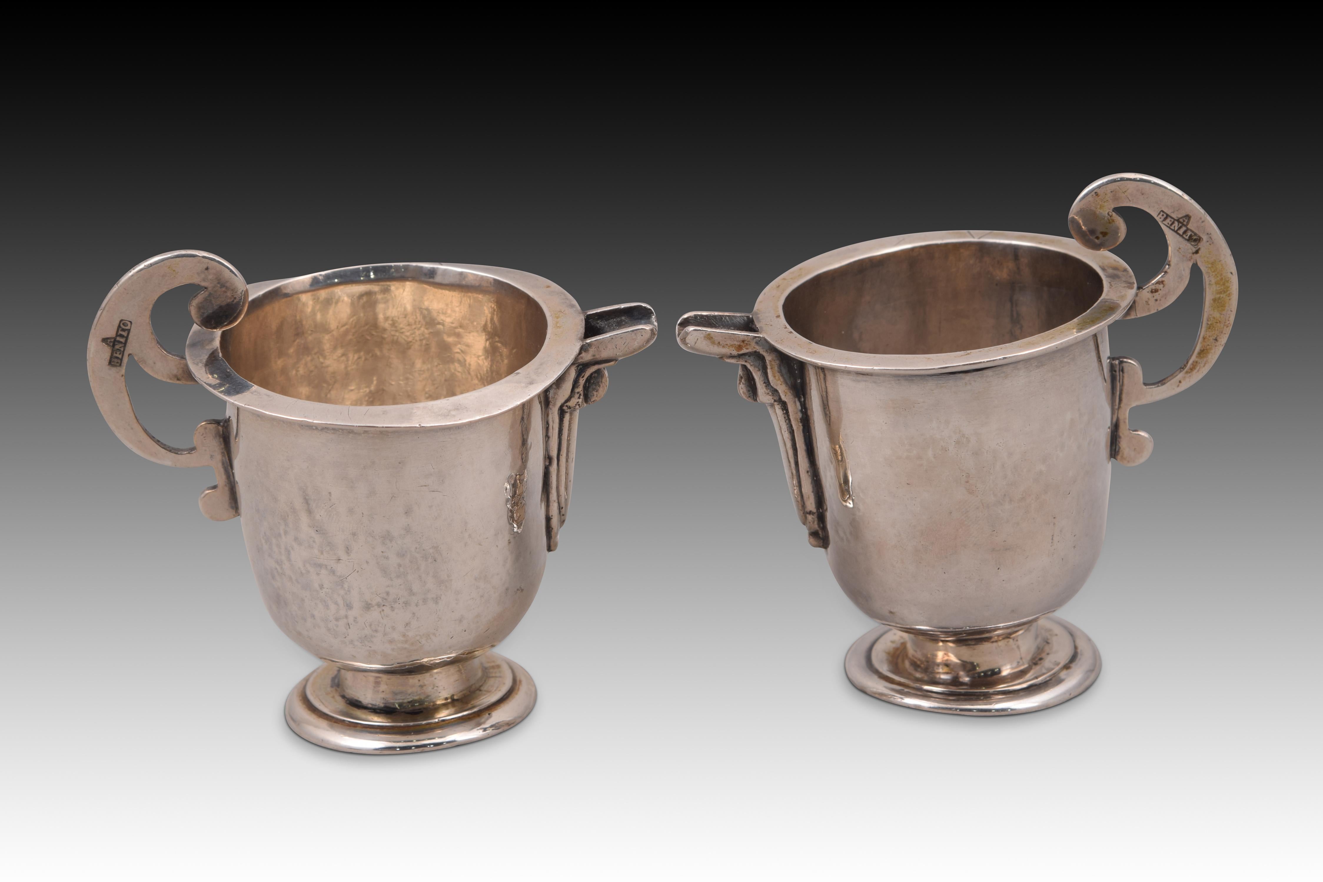 Pair of pitcher jugs. Silver. BENITO GOMEZ, Antonio (1775-1835). Segovia, Spain, 1801-1835.
 With contrast markings. 
Pair of spouted jugs with a circular base with moldings, a low conical foot and a tubular body finished in a hemisphere at the