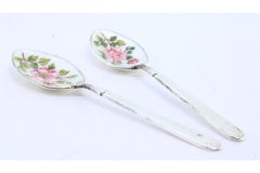 Two silver teaspoons with enameled floral shells and relief handles