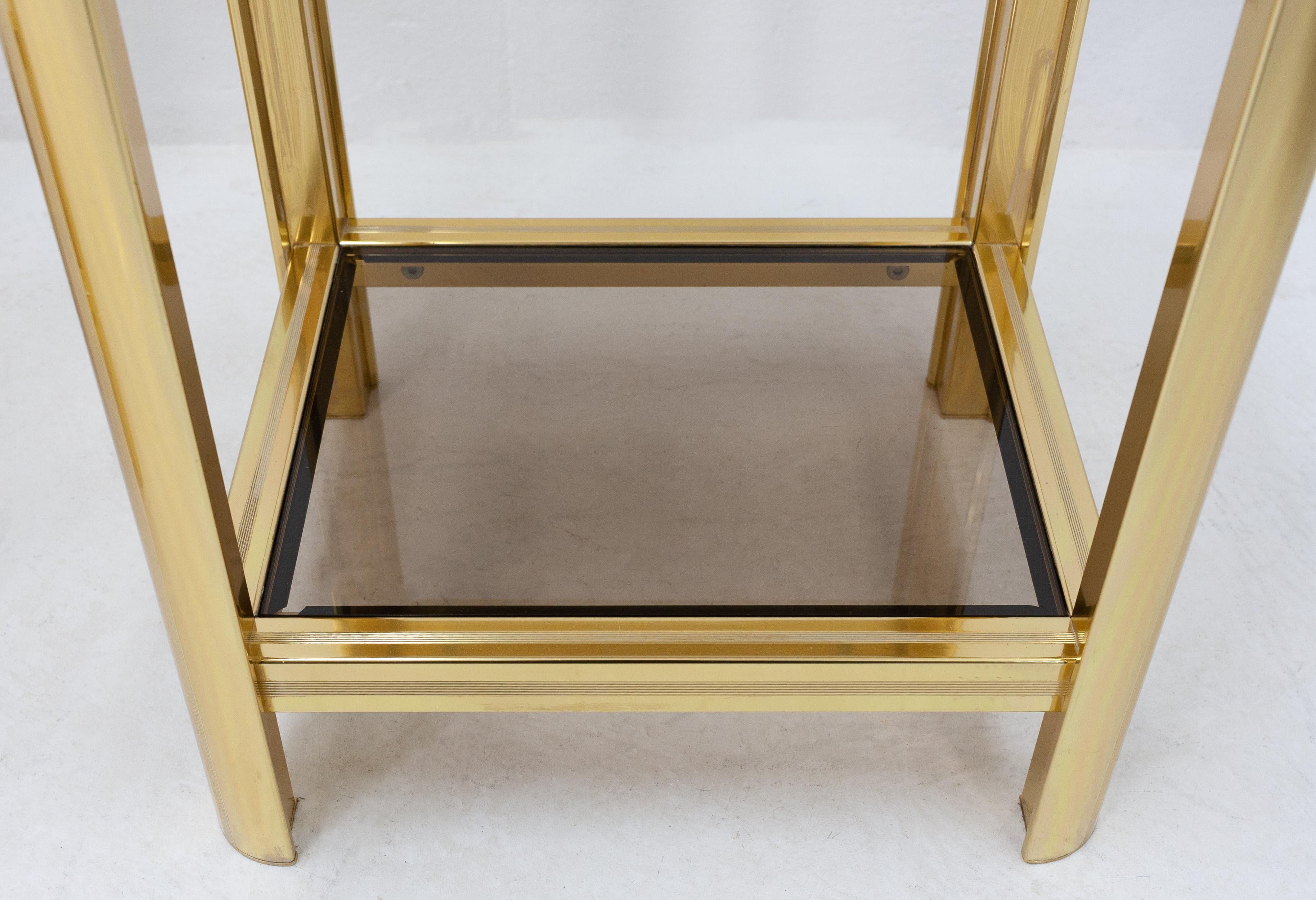 Two-tier brass side tables or night stands. Featuring smoked glass inlays. Still in very good condition. Made in France, 1970s. 
  