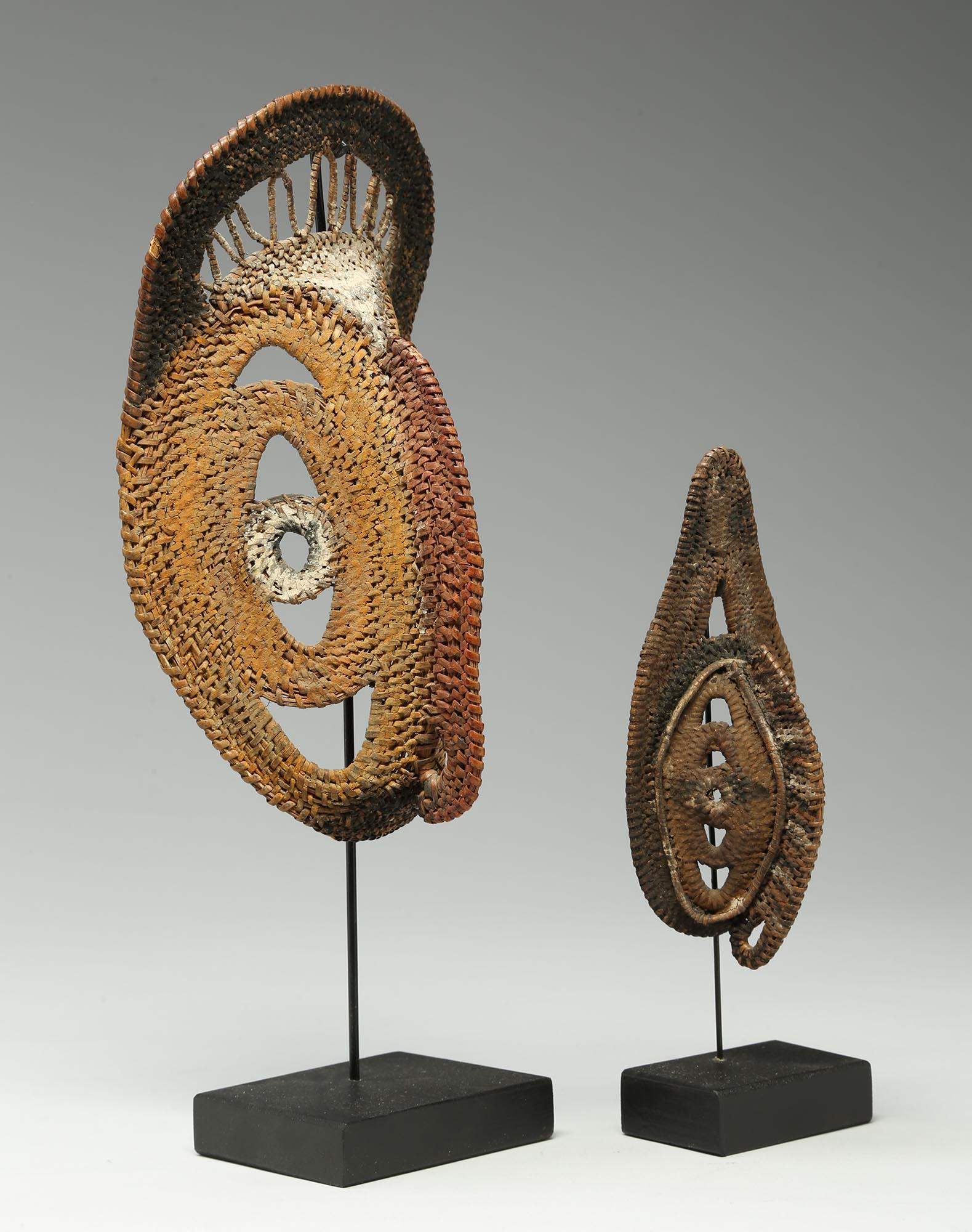 Two small tightly woven Basketry New Guinea Yam masks, with incrusted paints and surfaces. Used to decorate large yams during the annual harvest ceremonies. Great expressive small artworks. Each on a hanging wood and metal base as shown. Measures: