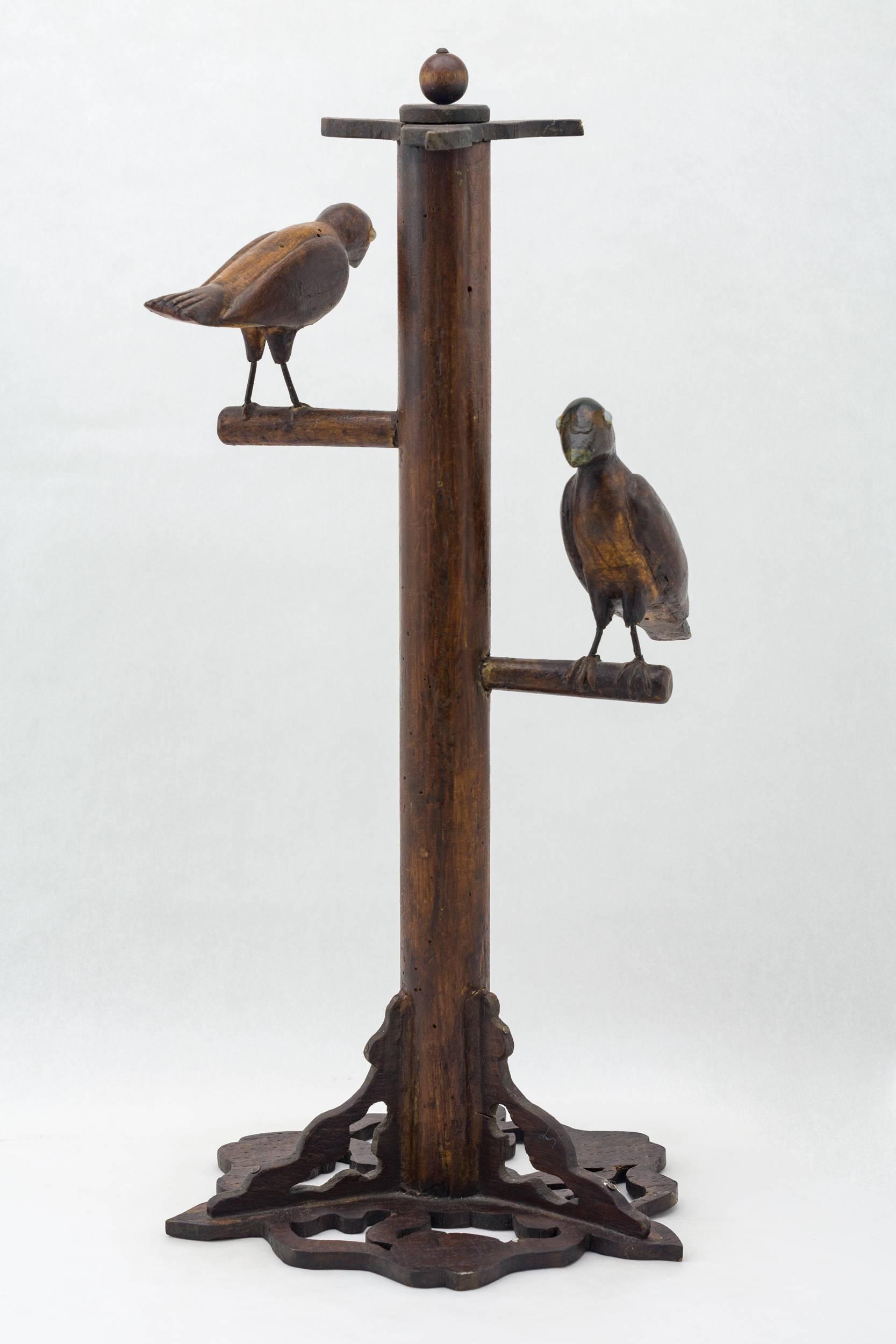 Birds are finely carved with raised wings, wired legs and white glass eyes
the perch has a pierced scrolled base and top. Made of Pine with painted beaks
and stain.