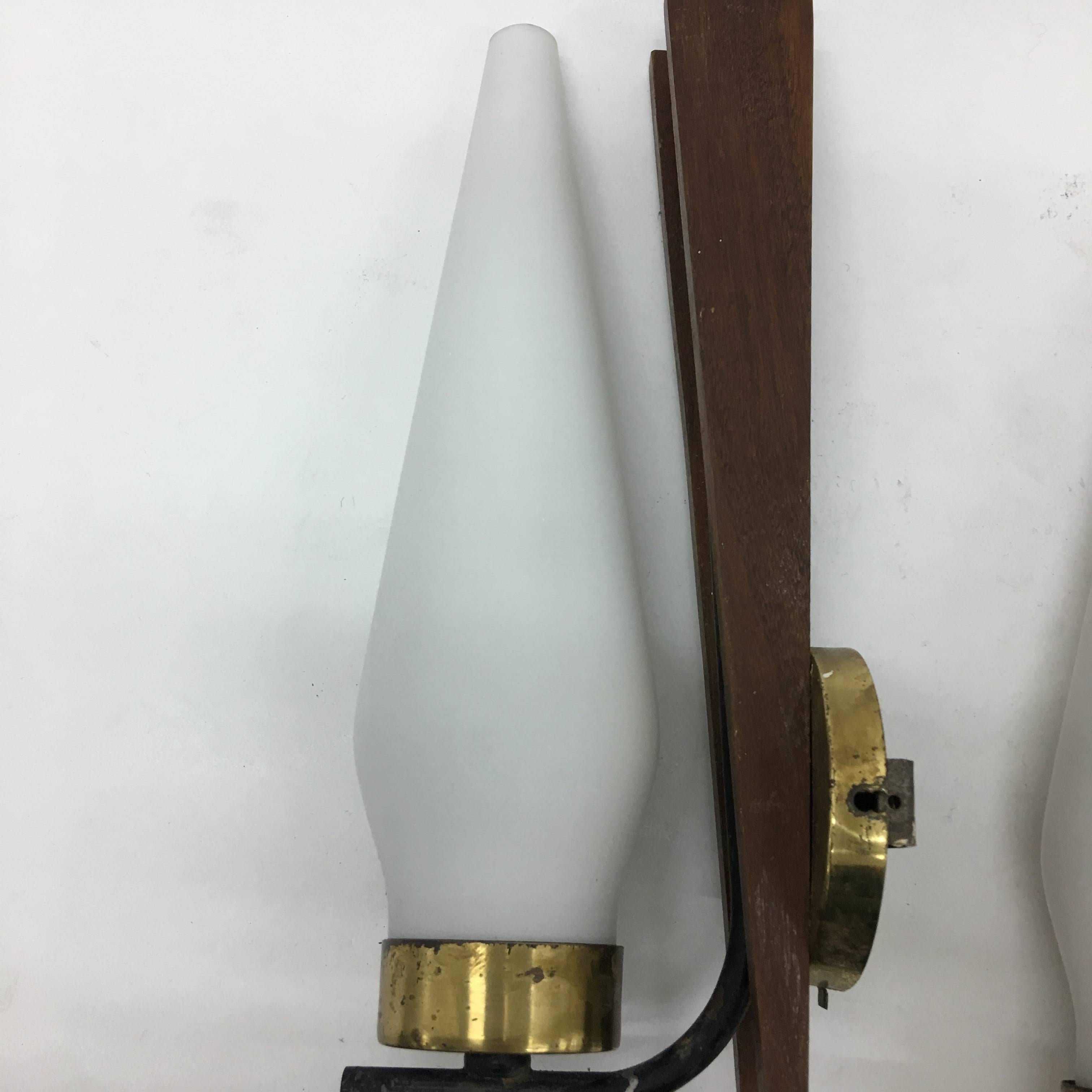 Two wall sconces in brass, teak and glass designed and manufactured in Italy in the 1950s in the style of Stilnovo. They work with both 110 and 220 Volt and need regular e14 bulbs.