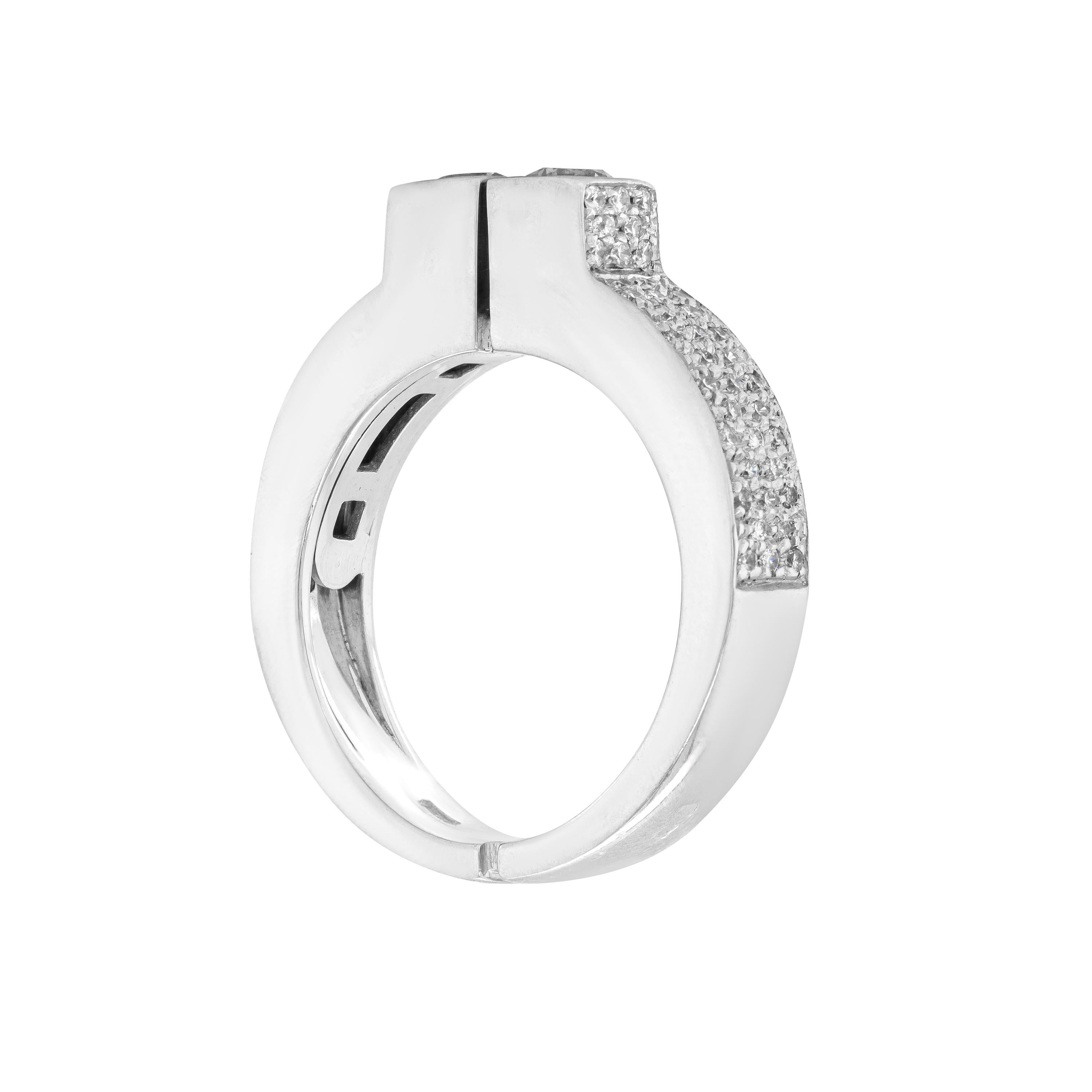 Questo anello unico presenta due diamanti rotondi taglio brillante del peso di circa 0,20 carati ciascuno, incastonati l'uno accanto all'altro in una montatura quadrata. Le due pietre sono accompagnate da spalle di diamanti incastonati a pavé e