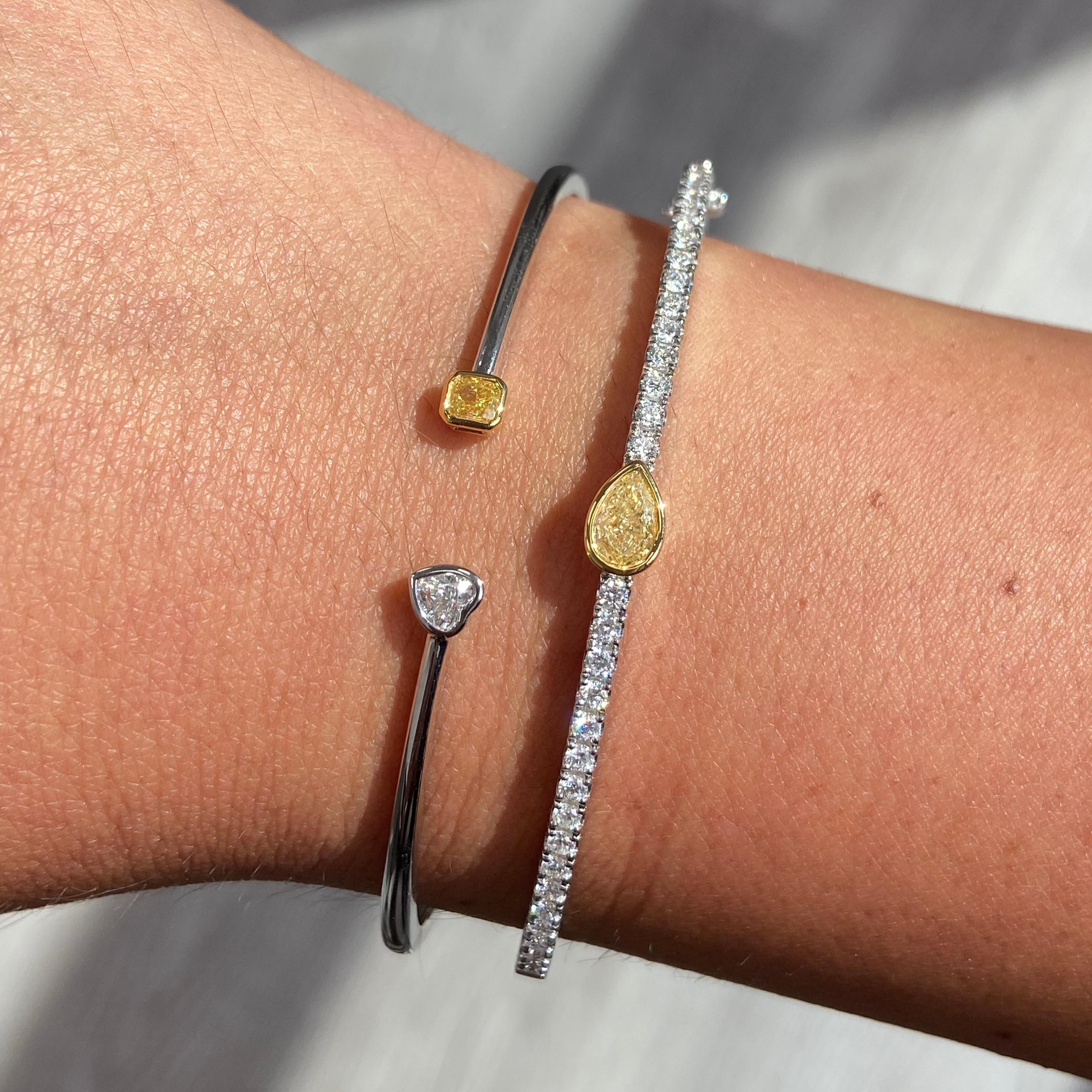 0.39 Carats Total 
0.22 Carat Light Yellow Radiant Cut 
0.17 F Color Heart Shape Diamond 
VS+ Clarity 
Crafted in 18k White Gold Bezel Cuff Bracelet 

At Rare Colors, you can experience the elegance of our exquisite fancy colored diamonds in person.