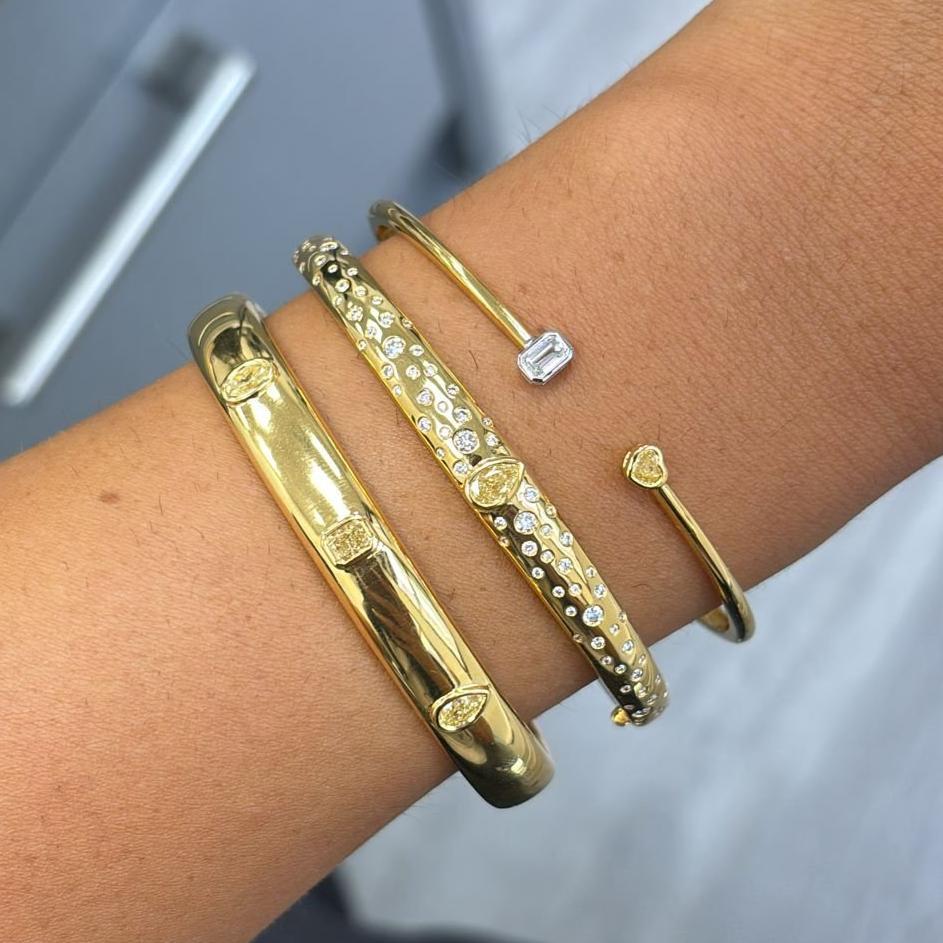 0.39 Carats Total 
0.22 Carat Emerald Cut F Color
0.17 Light Yellow Heart Shape Diamond 
VS+ Clarity 
Size 7 wrist
Crafted in 18k Yellow Gold Bezel Cuff Bracelet 

At Rare Colors, you can experience the elegance of our exquisite fancy colored