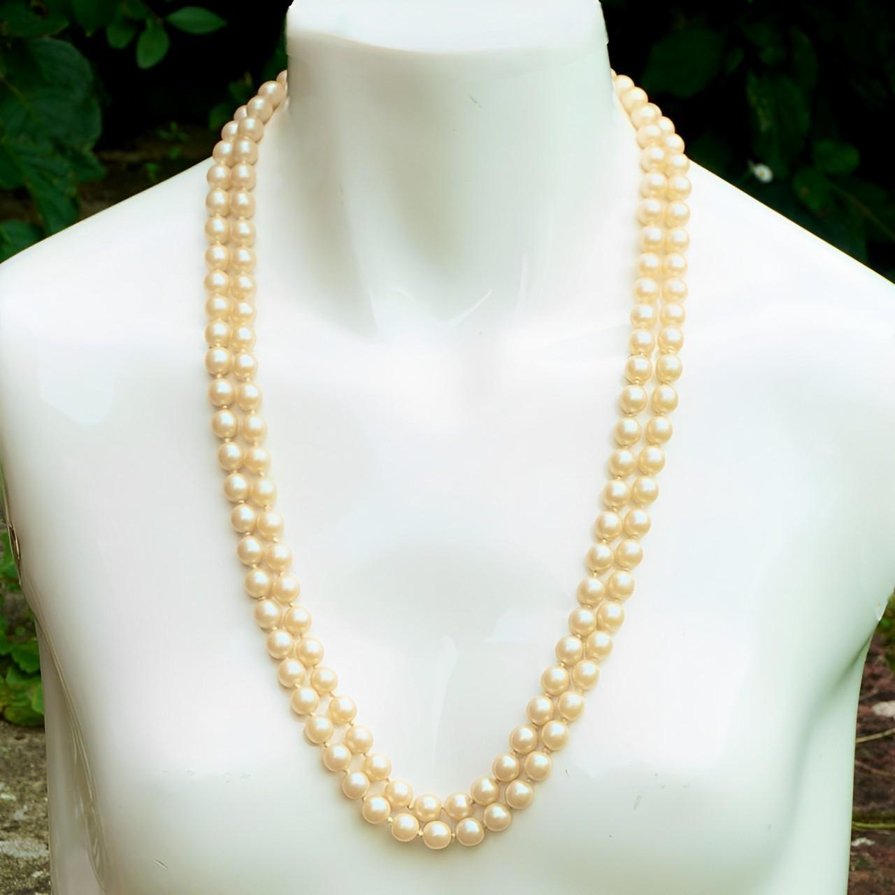 Beautiful two strand cream glass faux pearl necklace featuring a square gold plated clasp set with a single faux pearl and faux turquoise stones. The lustrous pearls are knotted between each pearl. The shortest strand measures length 64.5 cm / 25.4