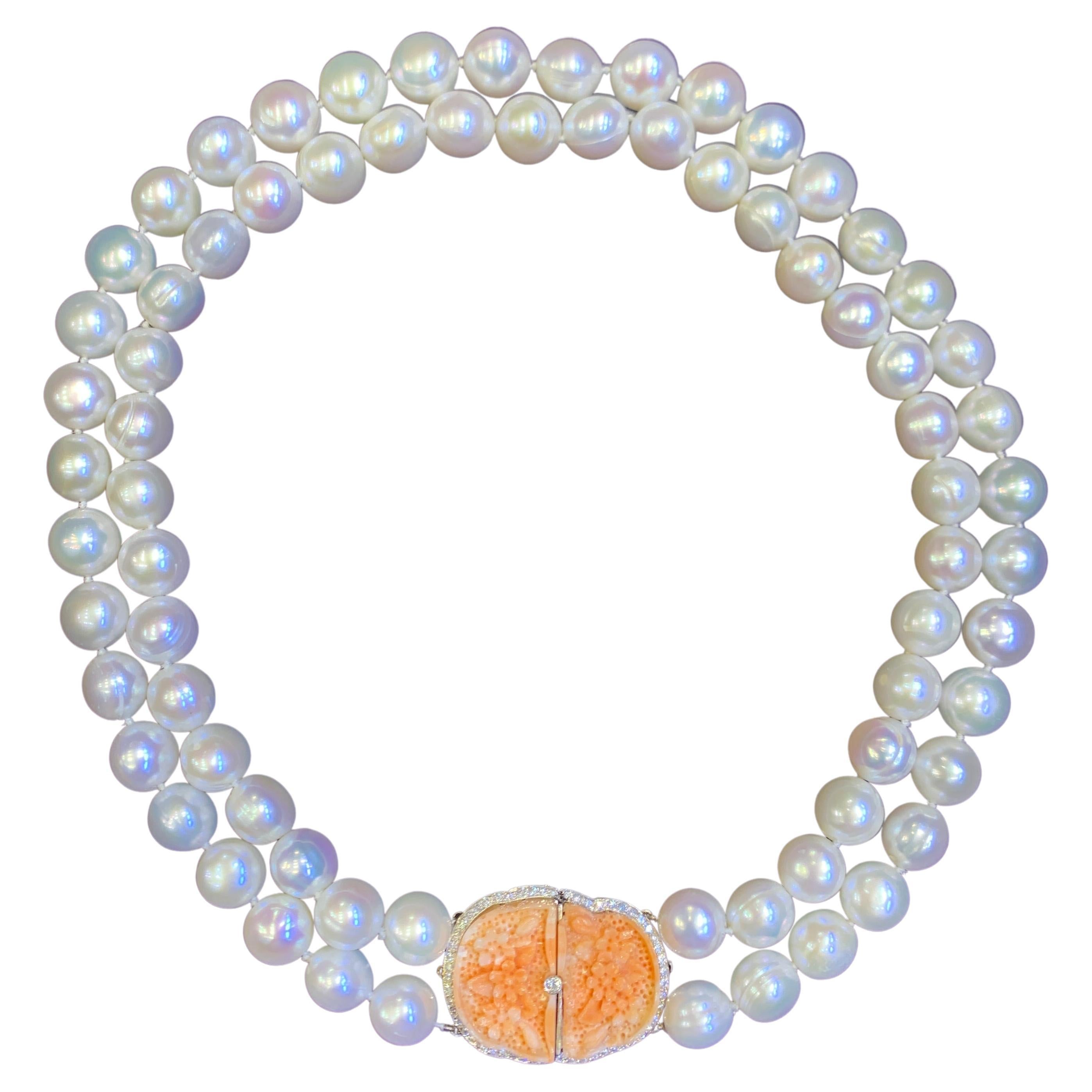 Two Strand Pearl & Carved Coral Necklace

This necklace consists of 2 strands of cultured pearls attached by an 18 karat white gold clasp set with 56 round cut diamonds and 2 beautifully carved floral motif corals

Stamped 750

Length: 18