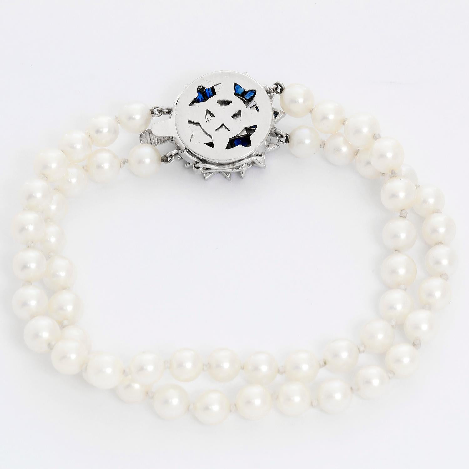 Two-strand Pearl & Sapphire Bracelet  - 14K White gold Flower with Blue Sapphires as a clasp of two strands of pearls. Bracelet length is 7 inches. Total width .25 in .